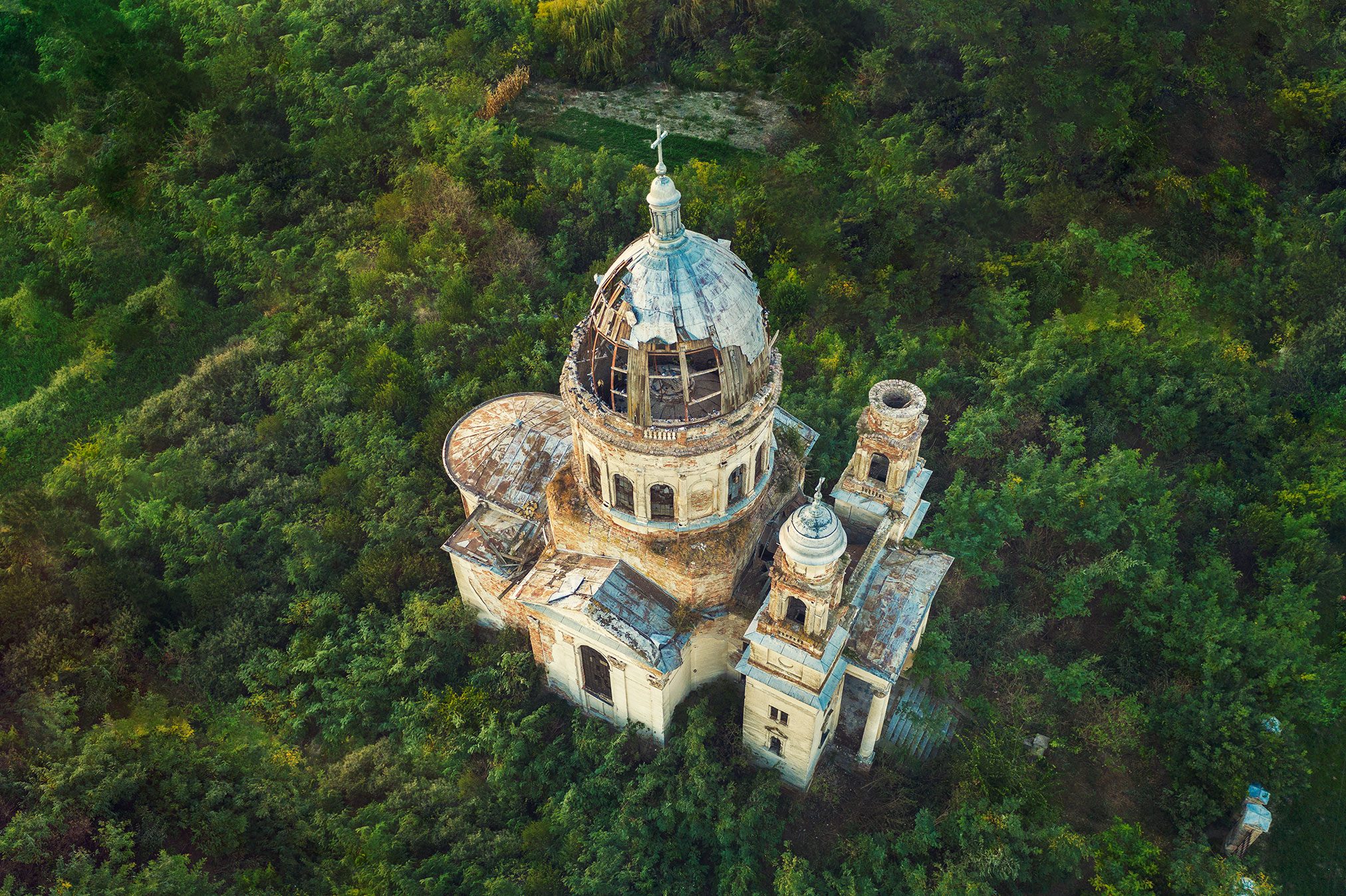 Church with an open dome amid dense forest near Bobda, Romania