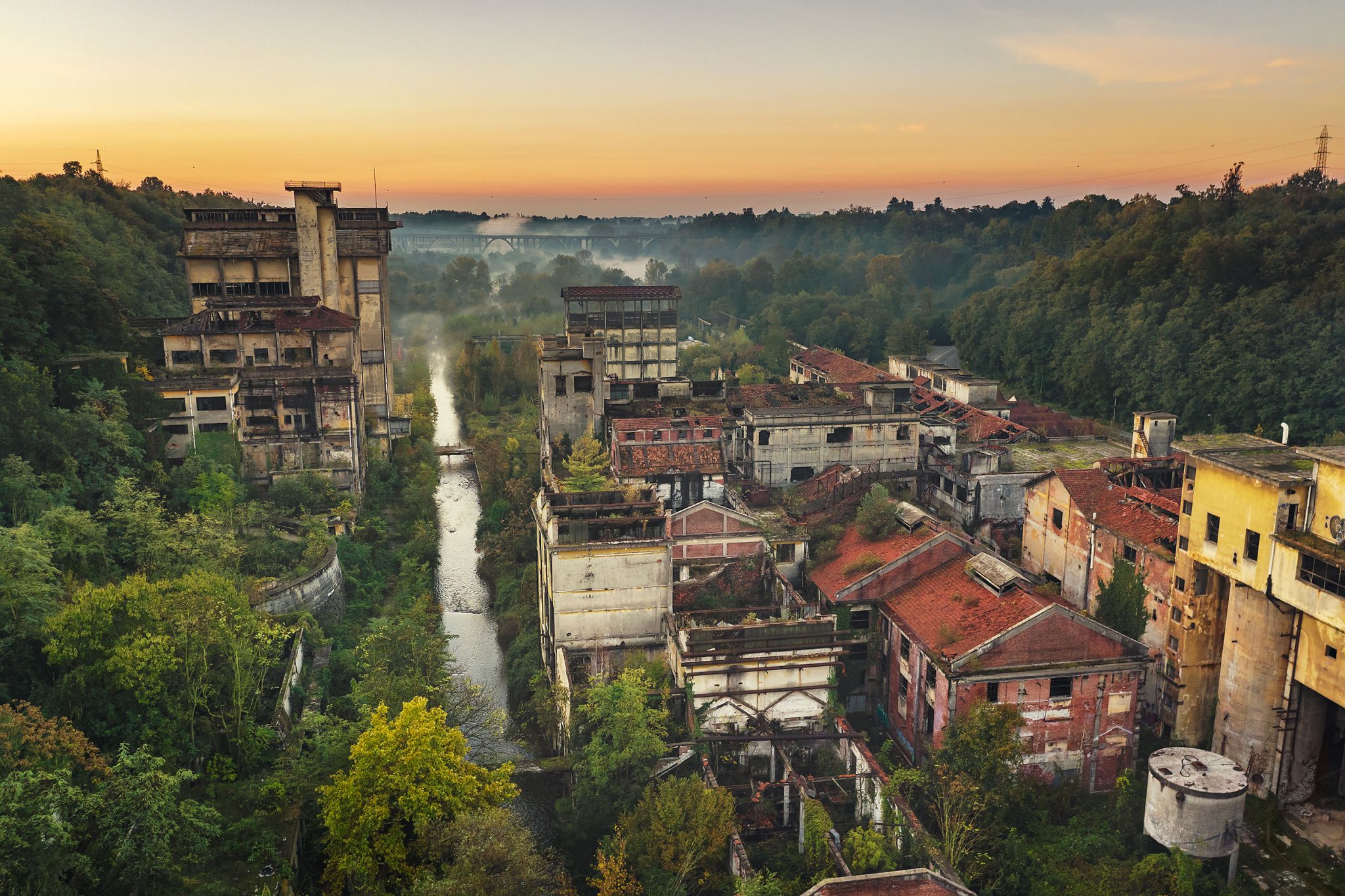 Abandoned paper mill by a river at dawn, Italy
