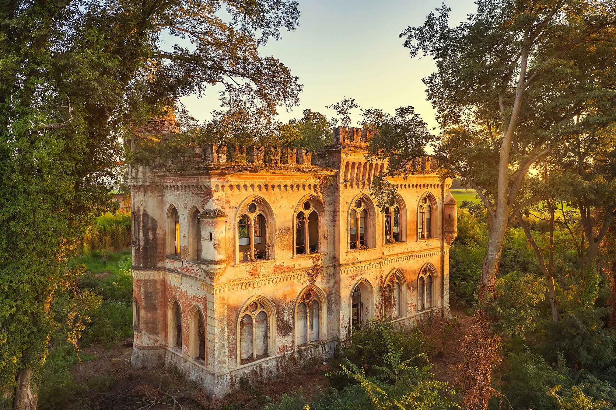 Former orangery with a crenellated crown and pointed arch windows, Italy