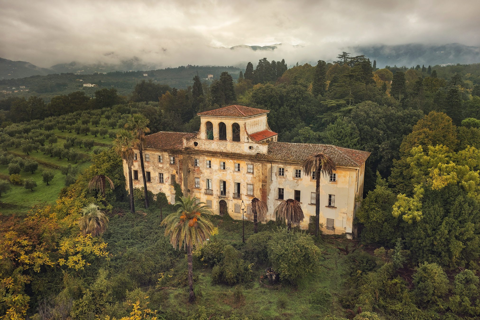 Abandoned villa with loggia and palm trees near Pistoia in Tuscany, Italy