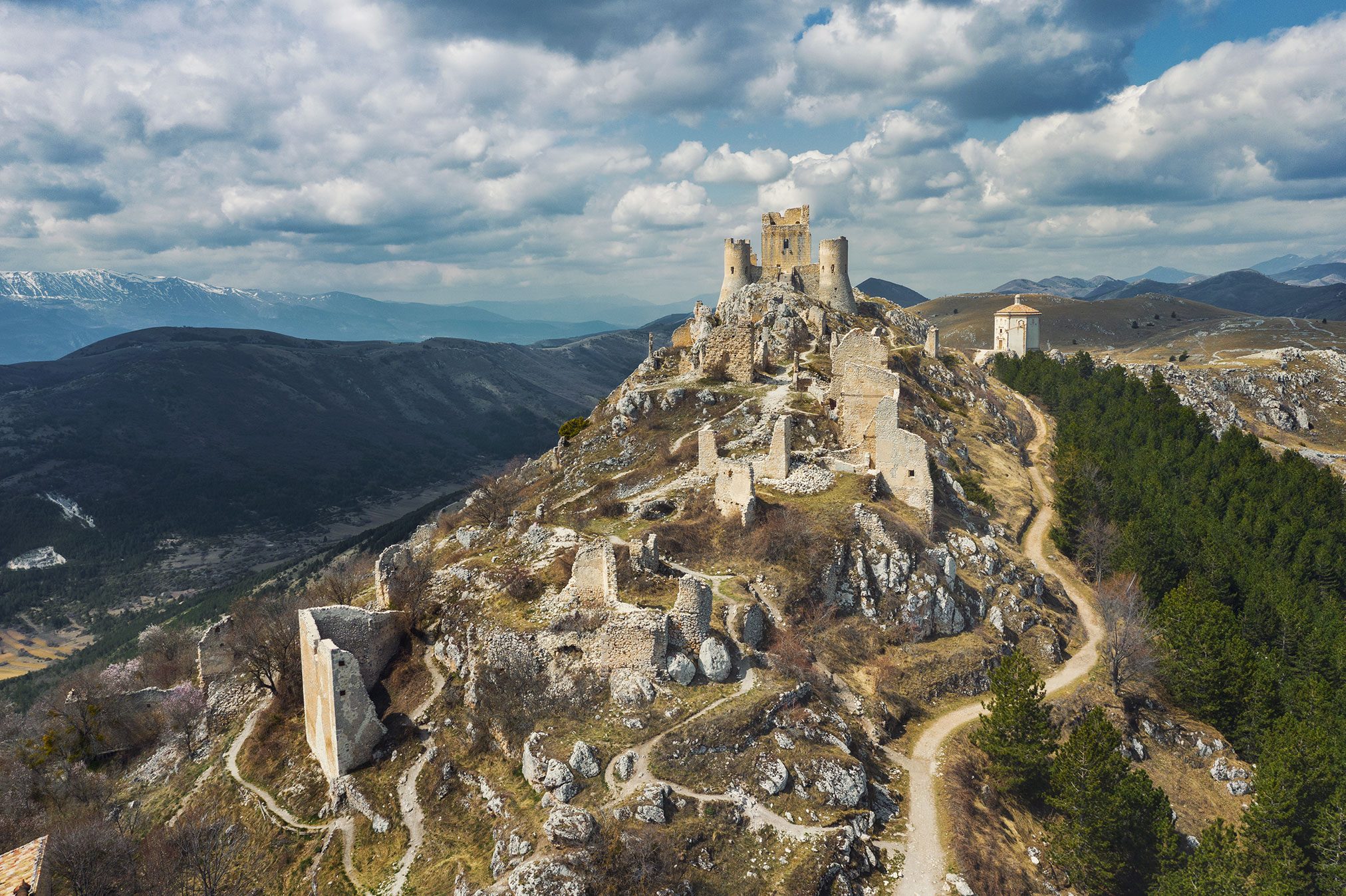 Castle ruin on a mountain ridge in the Abruzzo region with a view over the landscape, Italy