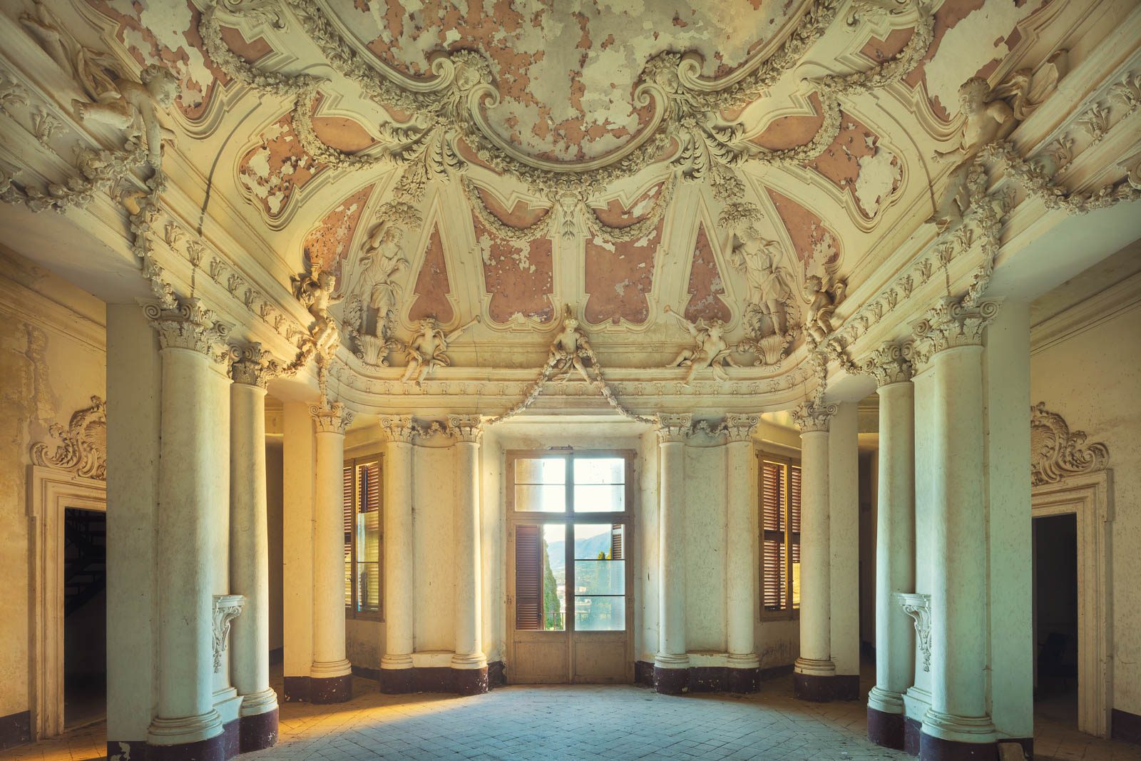 Oval rococo hall with a stucco ceiling and a ring of columns in a villa in Umbria, Italy