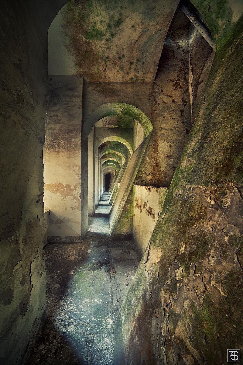 Moss-covered row of arches in a hydroelectric power plant in Umbria, Italy