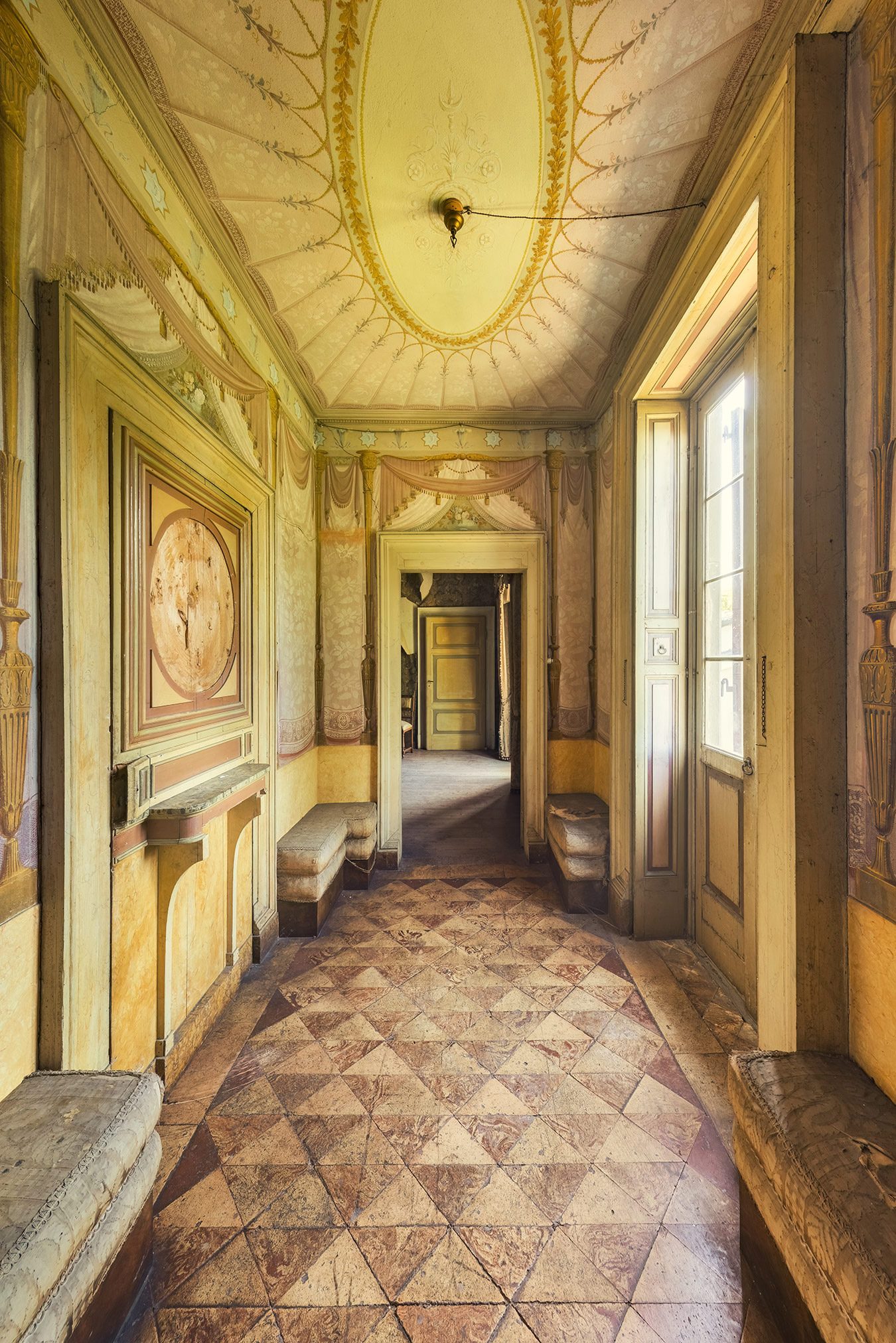 Painted corridor with an oval ceiling fresco in a historic Italian villa
