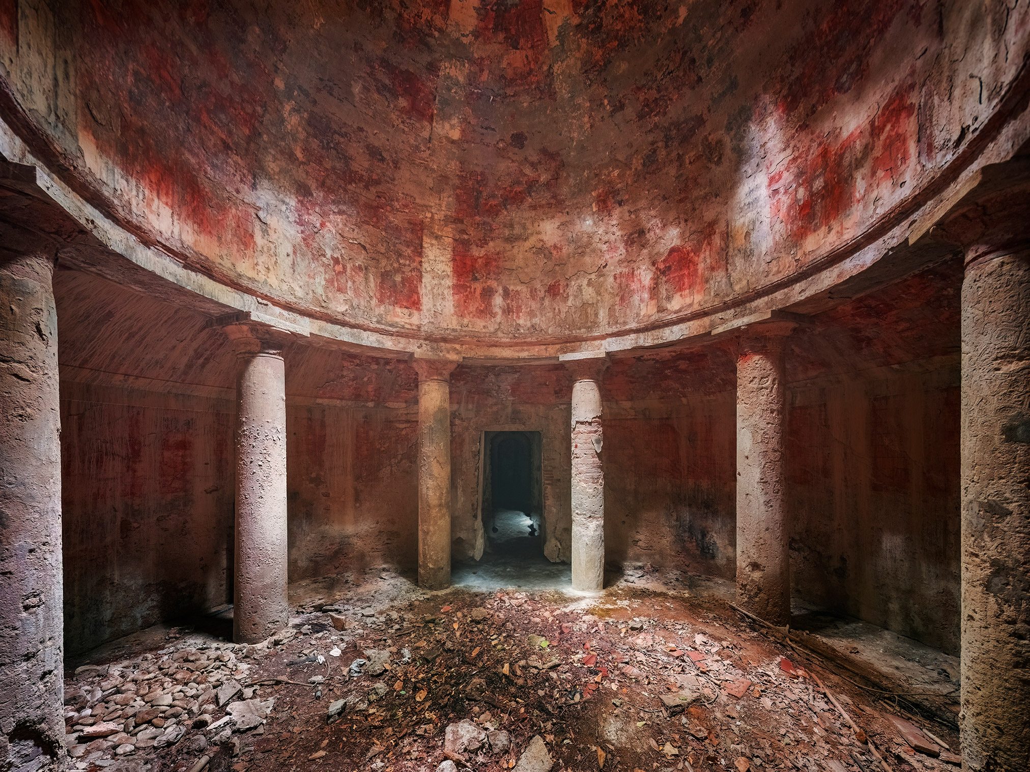 Round underground hall with red walls in an old bathhouse in Italy