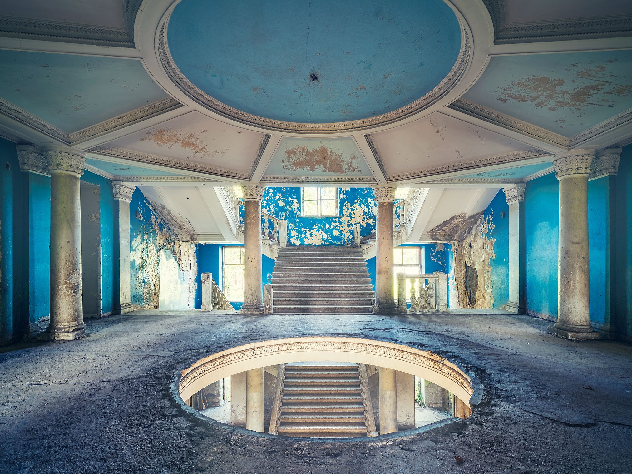 Blue rotunda with a double staircase in a forgotten hotel in Tskaltubo, Georgia