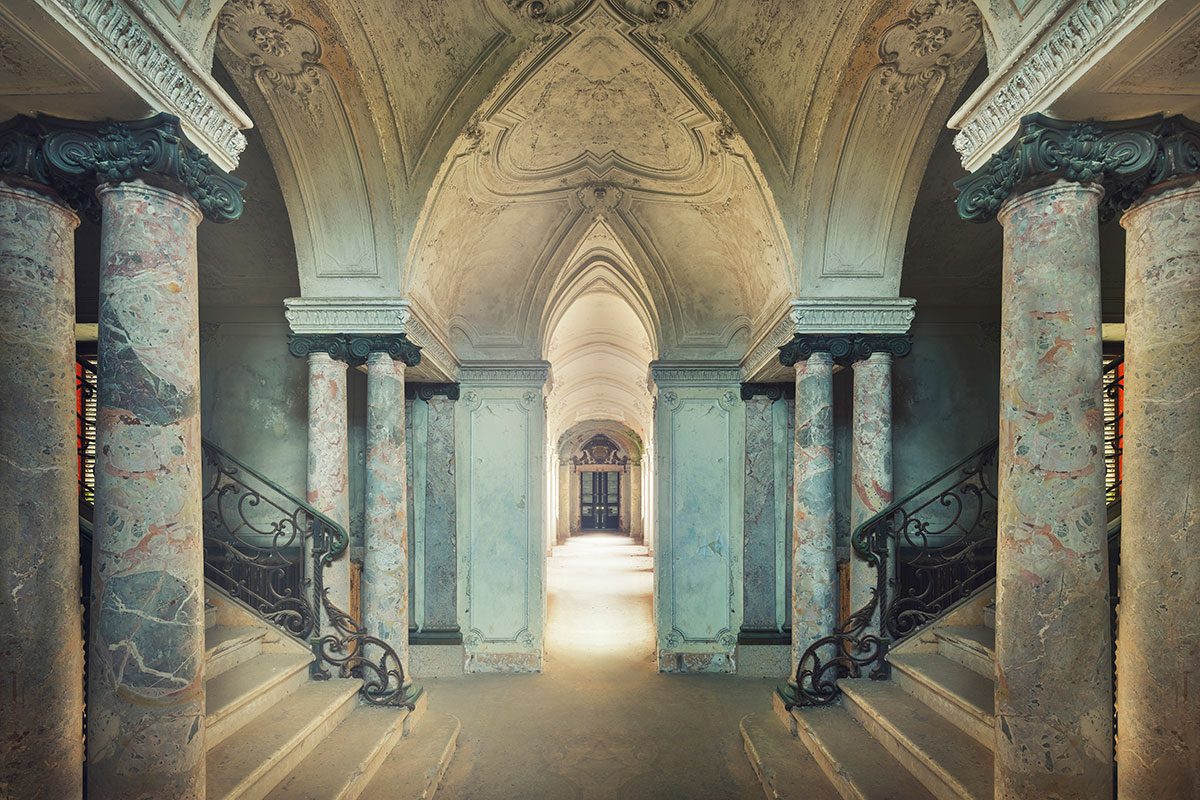 Marble columns with opposing staircases beneath a vaulted ceiling in a villa in the mountains of Piedmont, Italy
