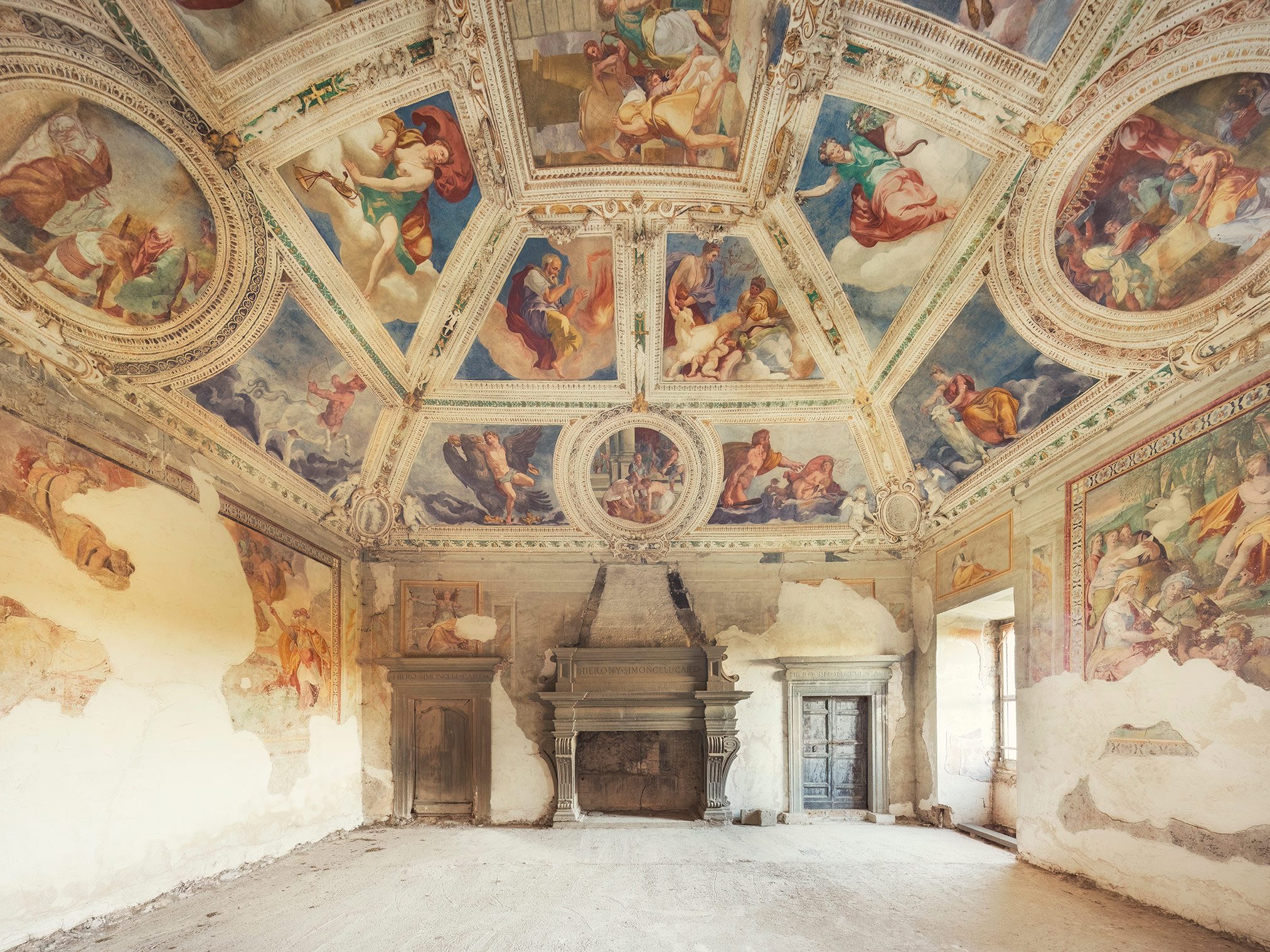 Fresco-decorated hall with a fireplace in an abandoned palazzo in Italy