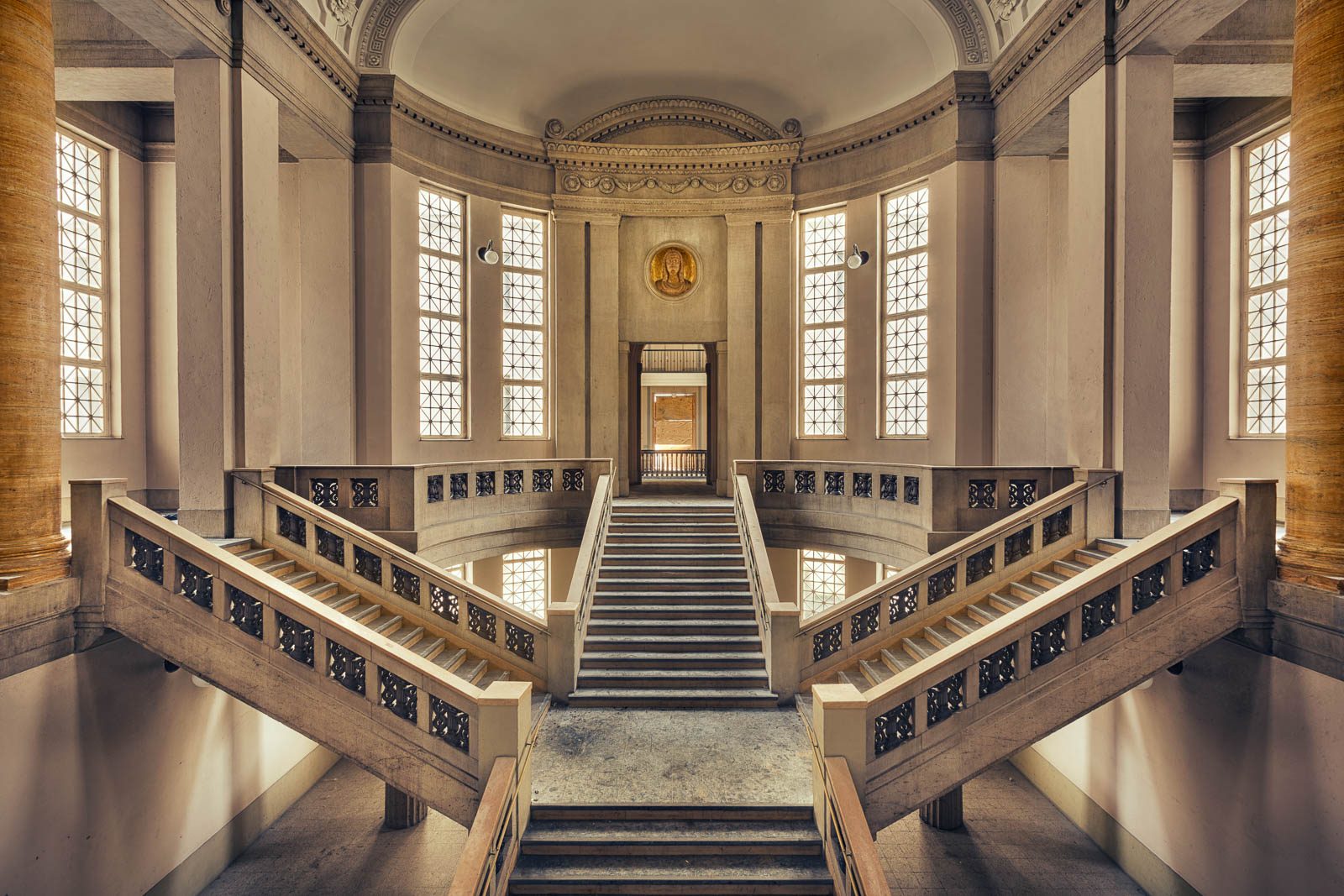Symmetrisches Treppenhaus mit Rundbogenfenstern im ehemaligen Landgericht in Düsseldorf, Deutschland