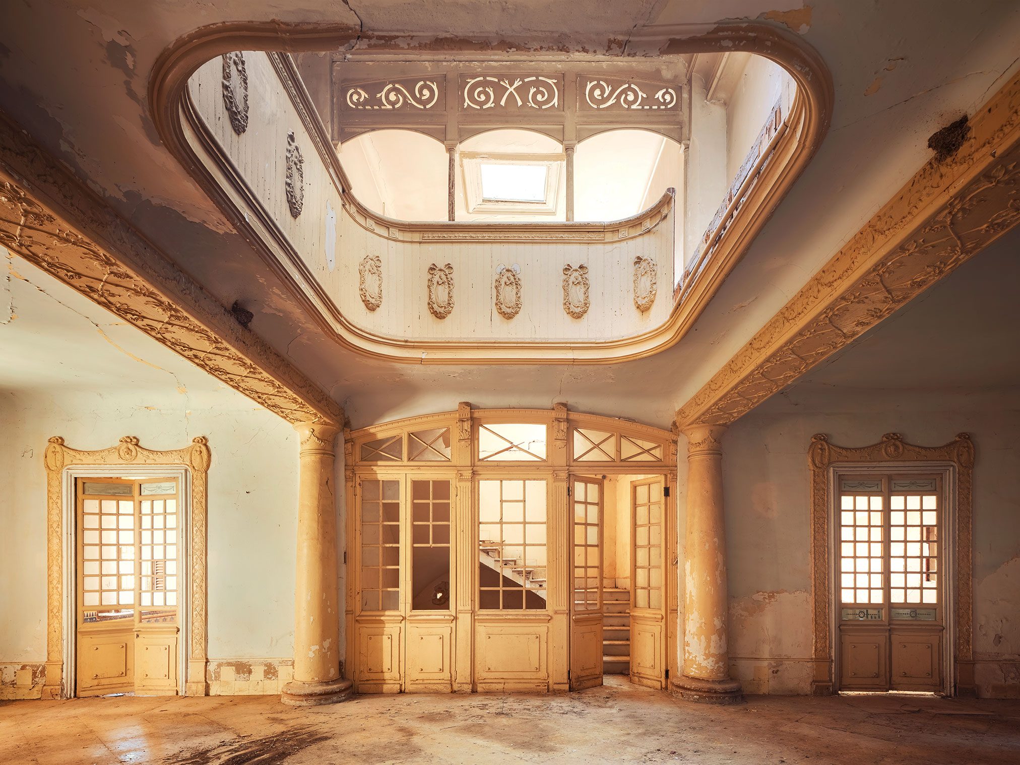 Light-filled entrance hall with a curved gallery in an art nouveau villa in Spain