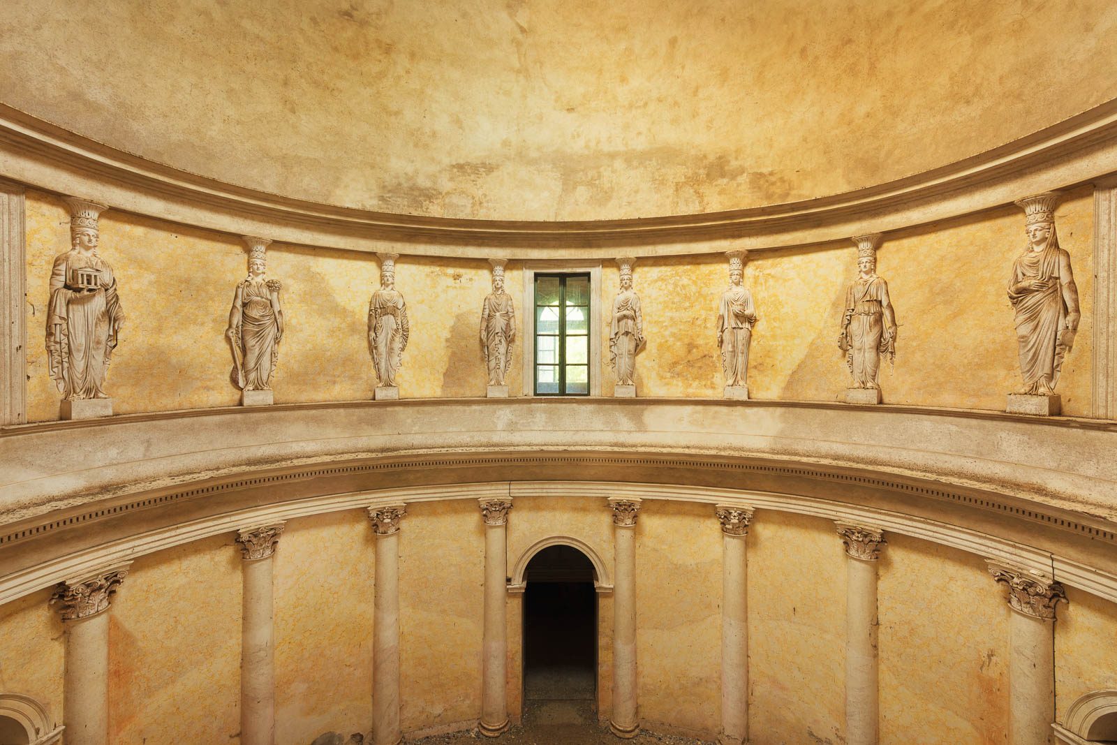 Oval rotunda with a gallery of figures and a central window in an abandoned villa in northern Italy
