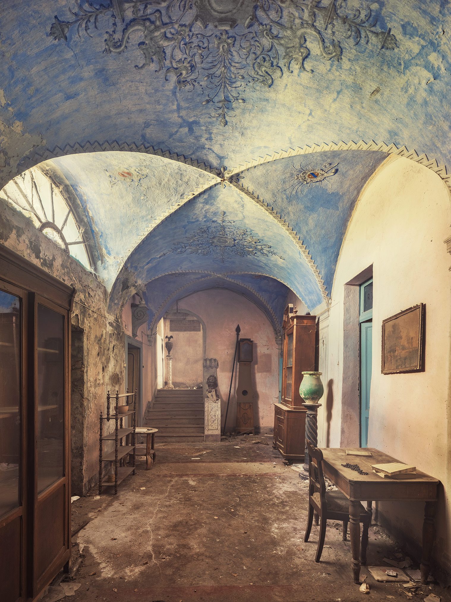 Blau bemalter Kreuzgang mit Antiquitäten in einer verlassenen Villa in Italien
