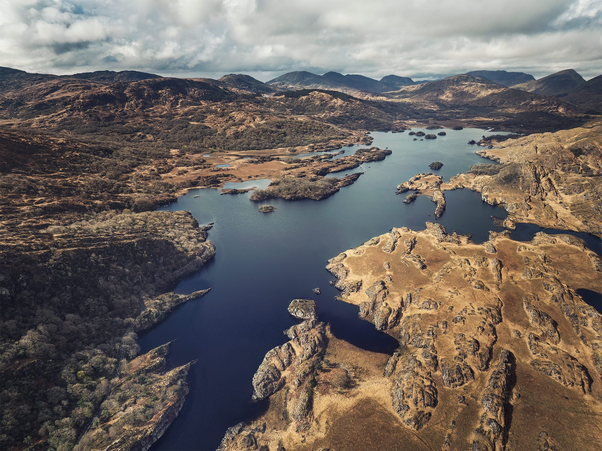 Aerial view of a lake with islands set against mountains in Ireland
