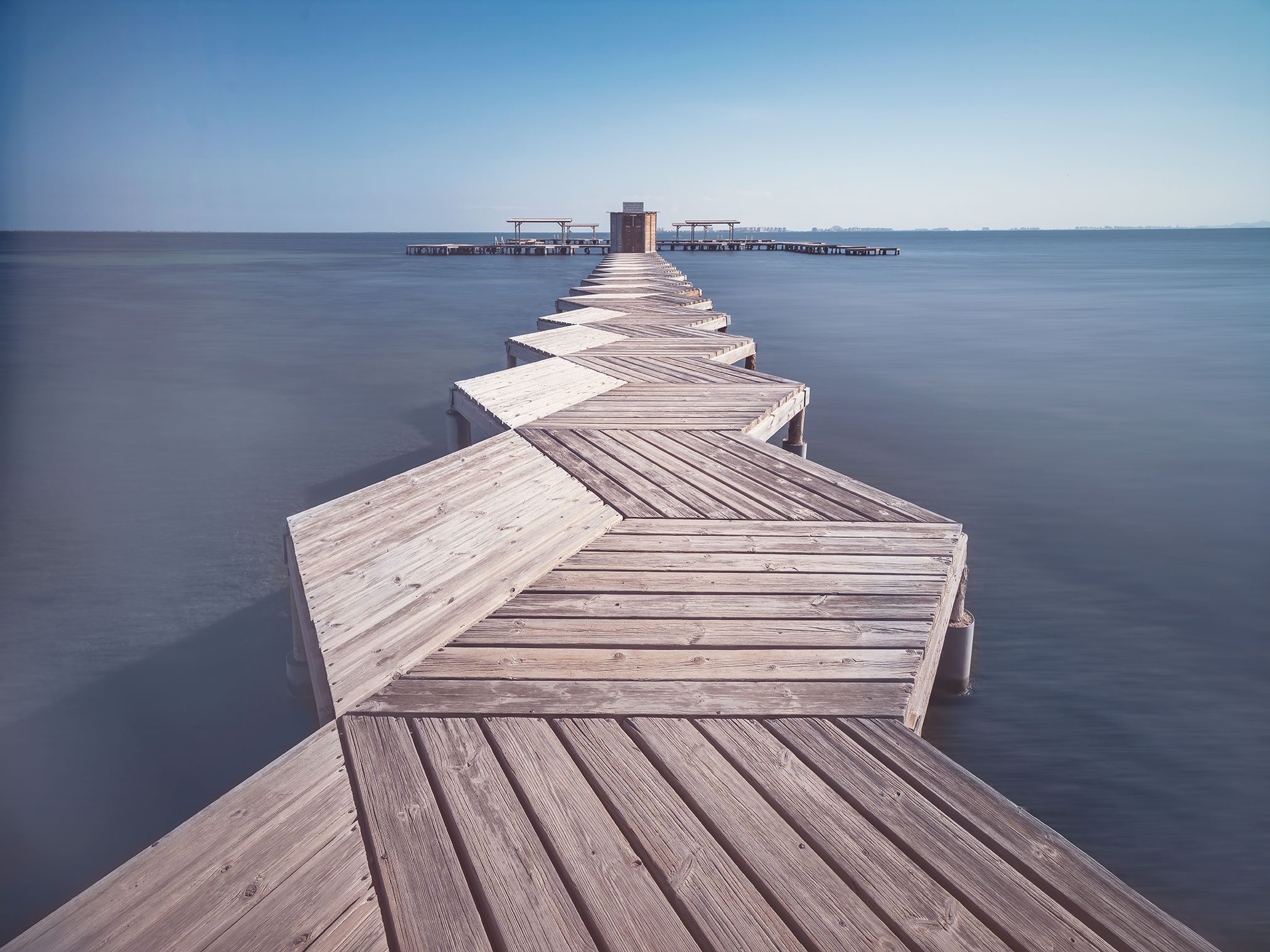 A zigzagging wooden jetty over the sea at Playa de Colón, Spain