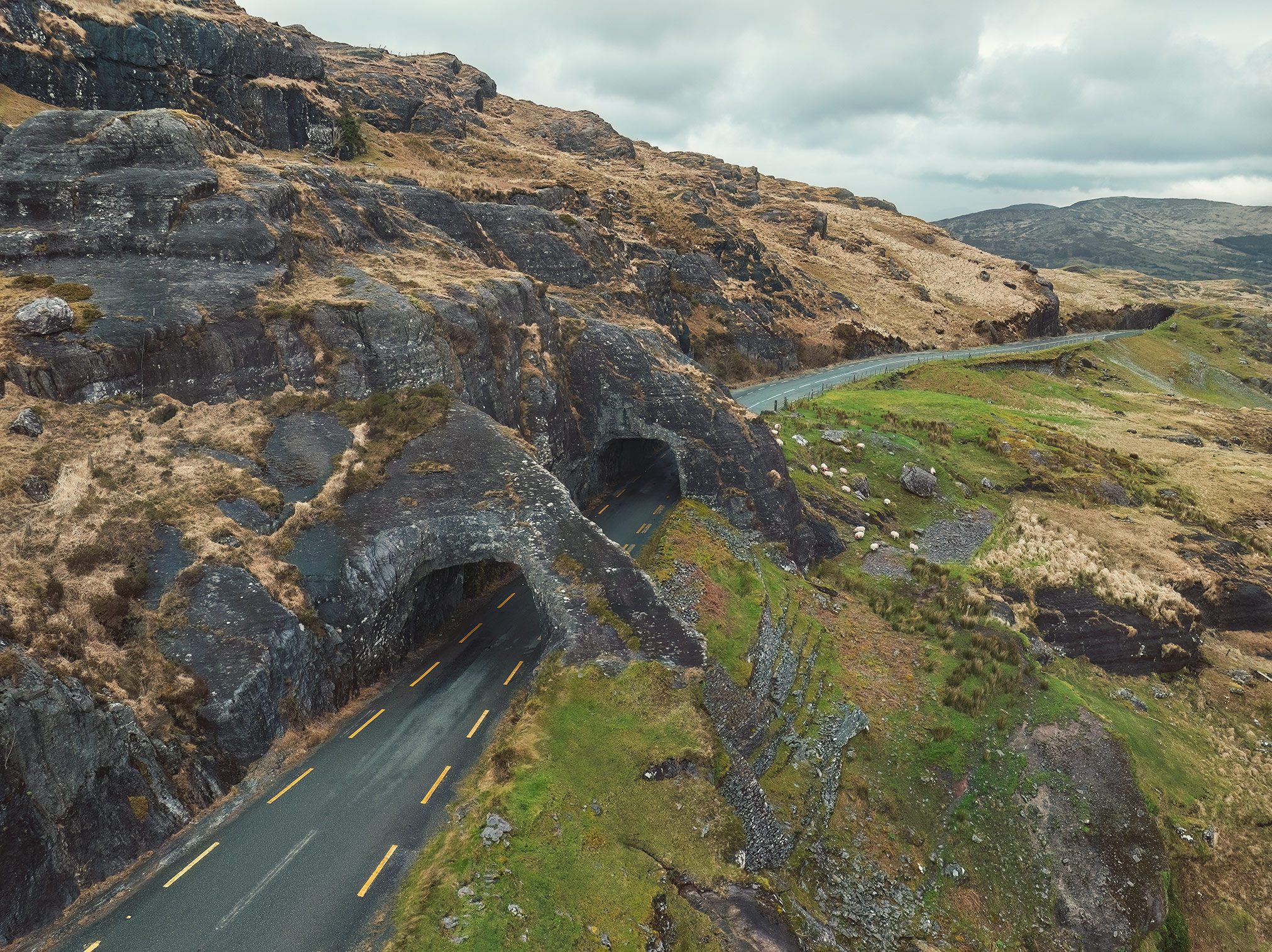 Road tunnels cut through rock at the Healy Pass in Ireland