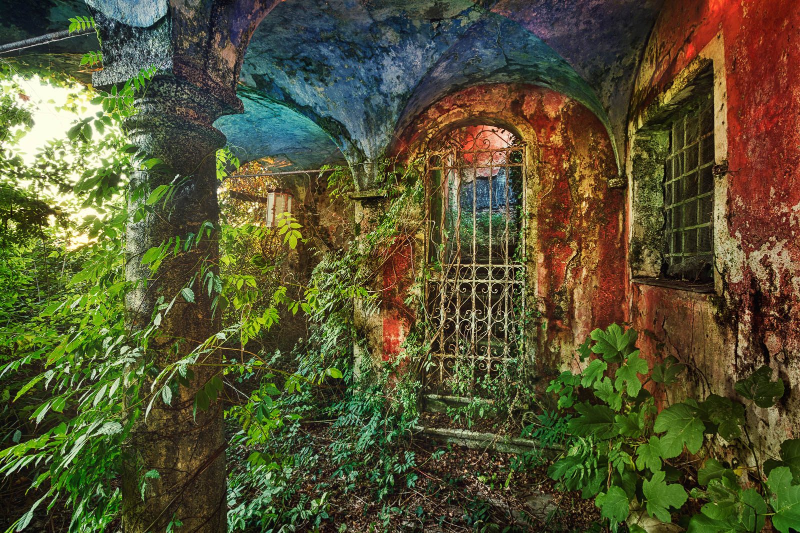 Rot-weiße Villa mit geschwungenen Giebeln vor blauem Himmel in der Toskana, Italien