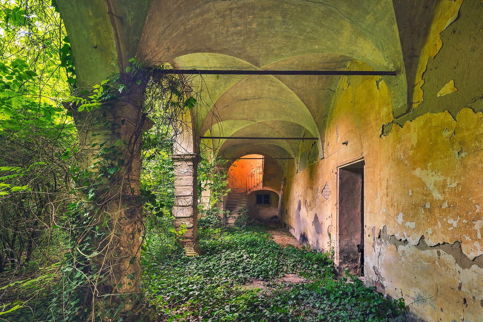 Gewölbte Arkade mit Blick auf eine Treppe in einem Palazzo in der Lombardei, Italien