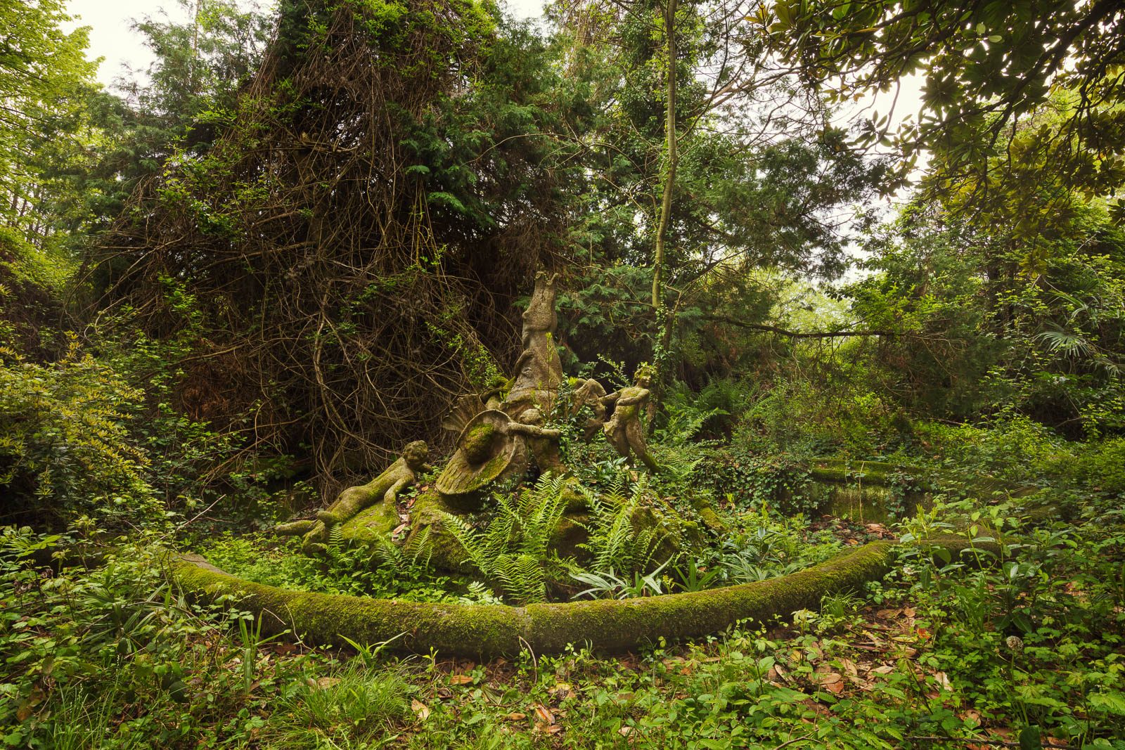 Bemooste Brunnenfiguren in einem verwunschenen Garten in Italien