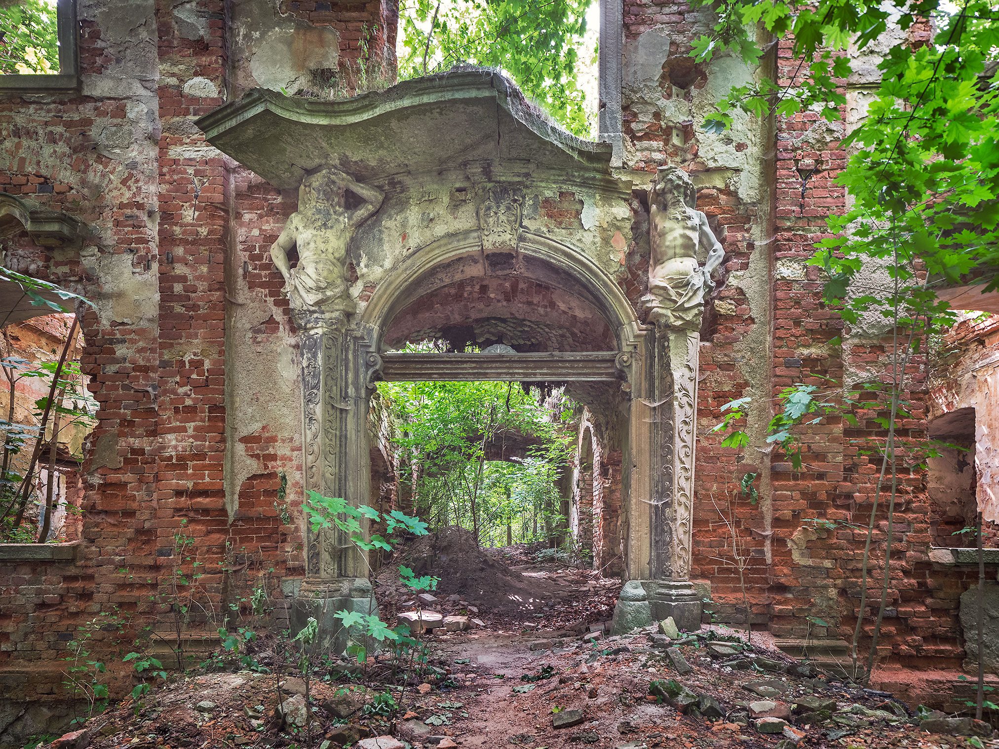 Stone portal with figures in the ruin of a manor house in Poland