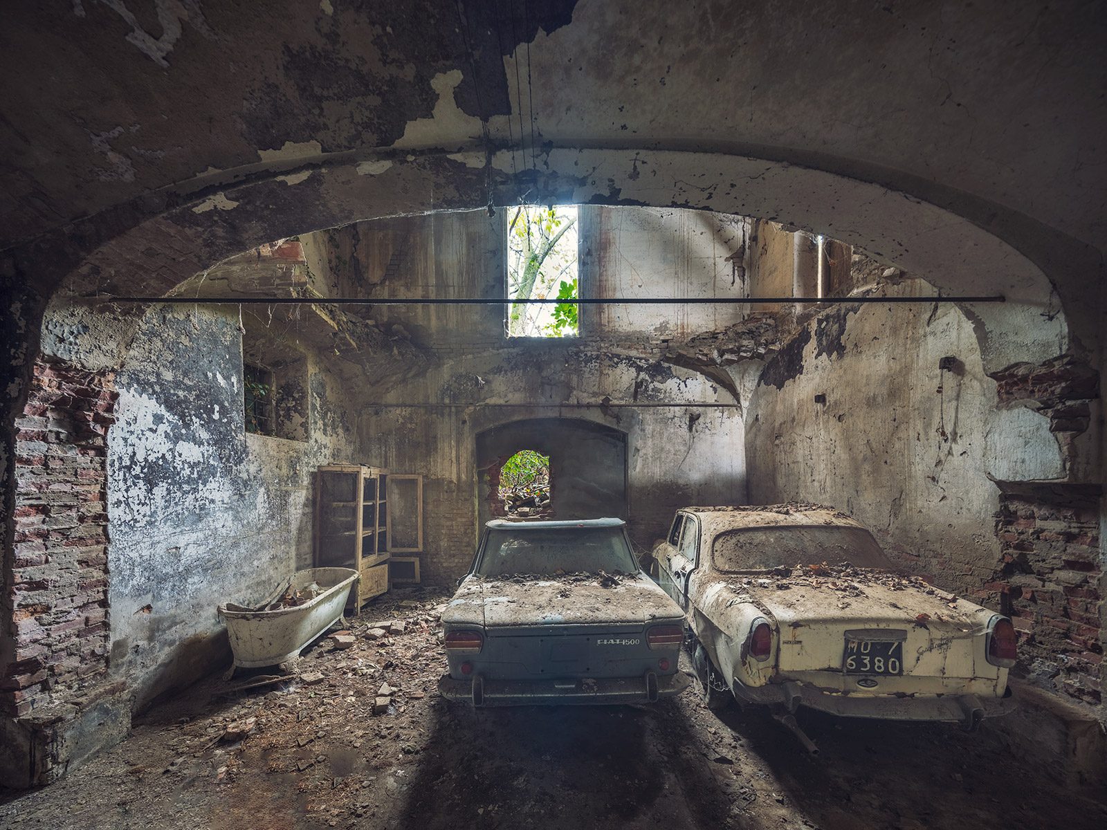 Zwei alte Autos in einer gewölbten Ruine in der Emilia Romagna, Italien