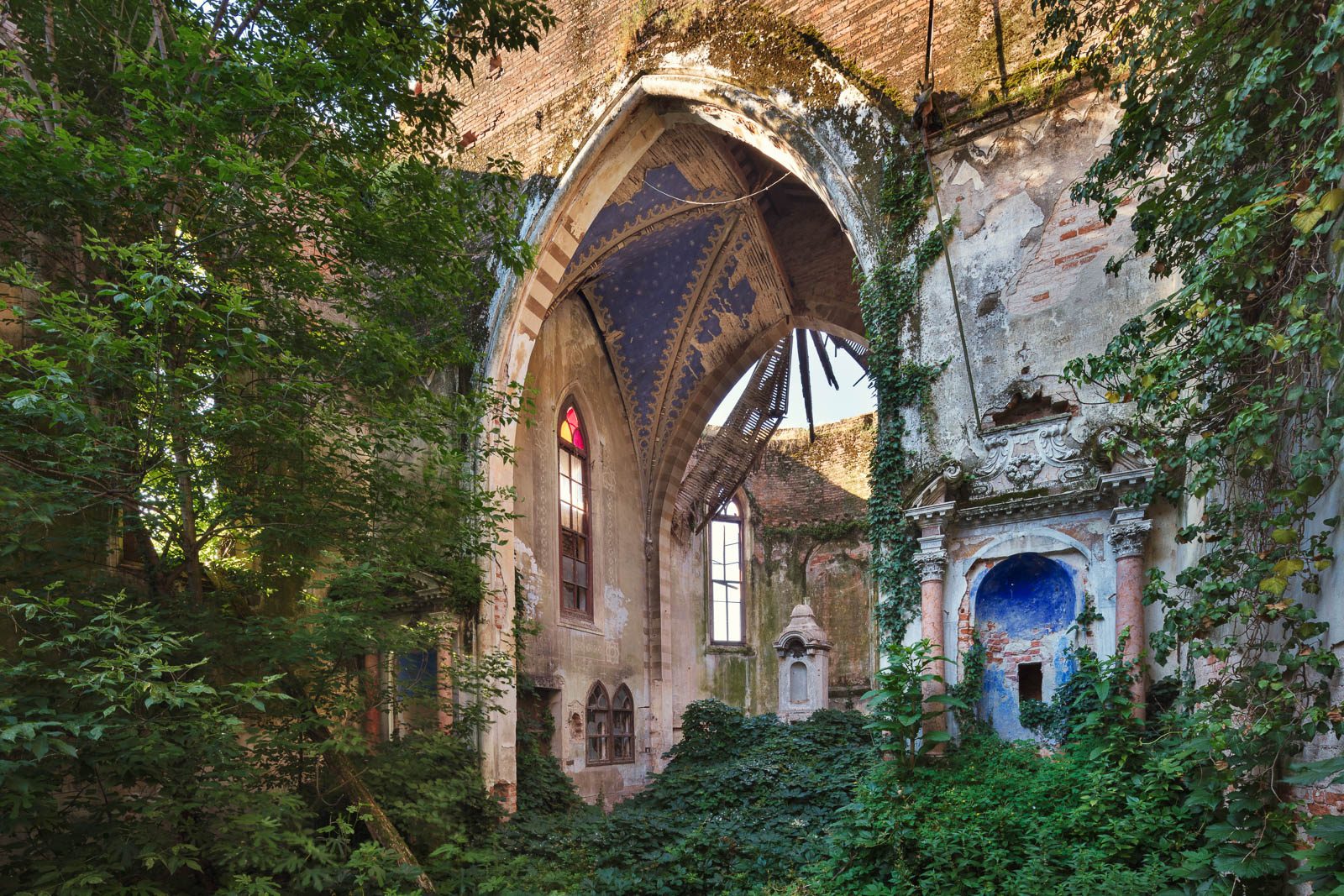 Forgotten church with ribbed ceiling in the forest in Italy