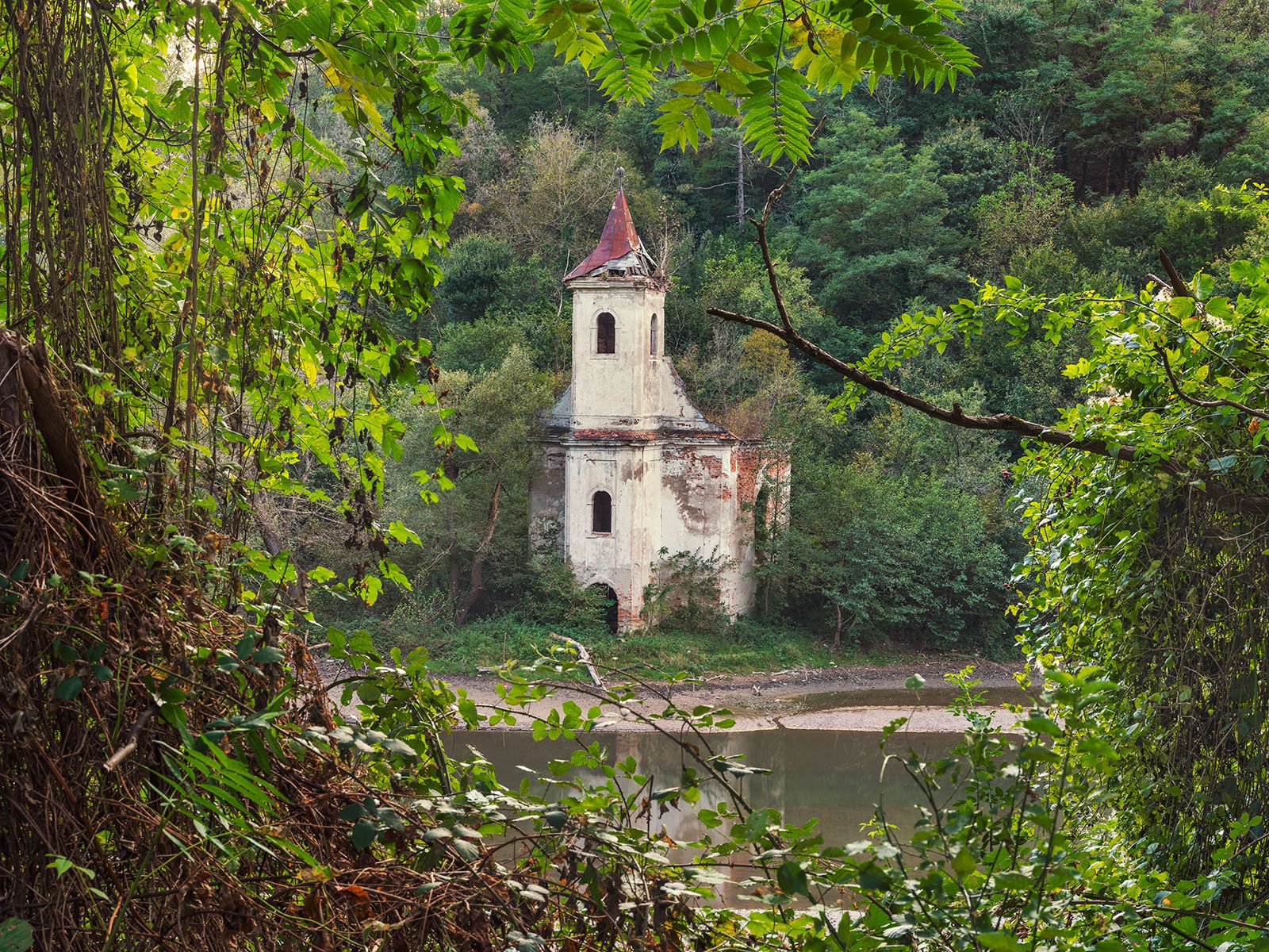 Kleiner Glockenturm an einem Fluss in Rumänien