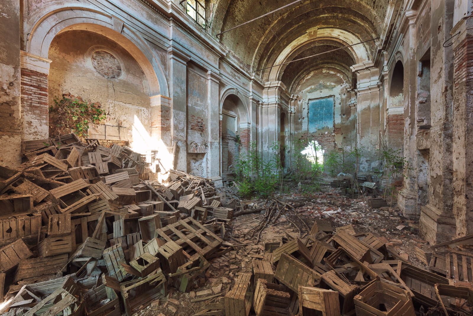 Church ruin with stacked wooden crates in Italy