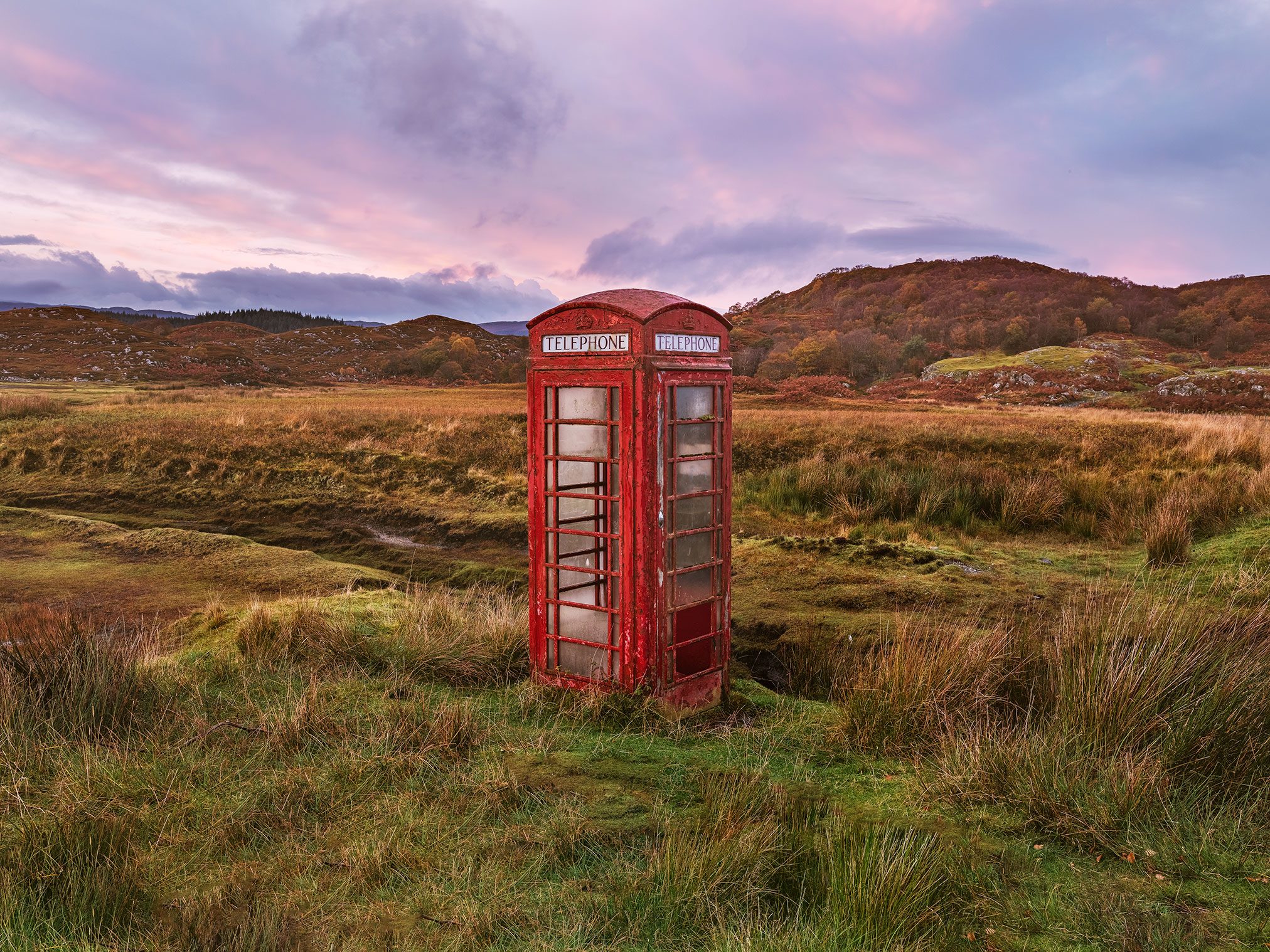 Red telephone box standing alone in a moorland in Scotland