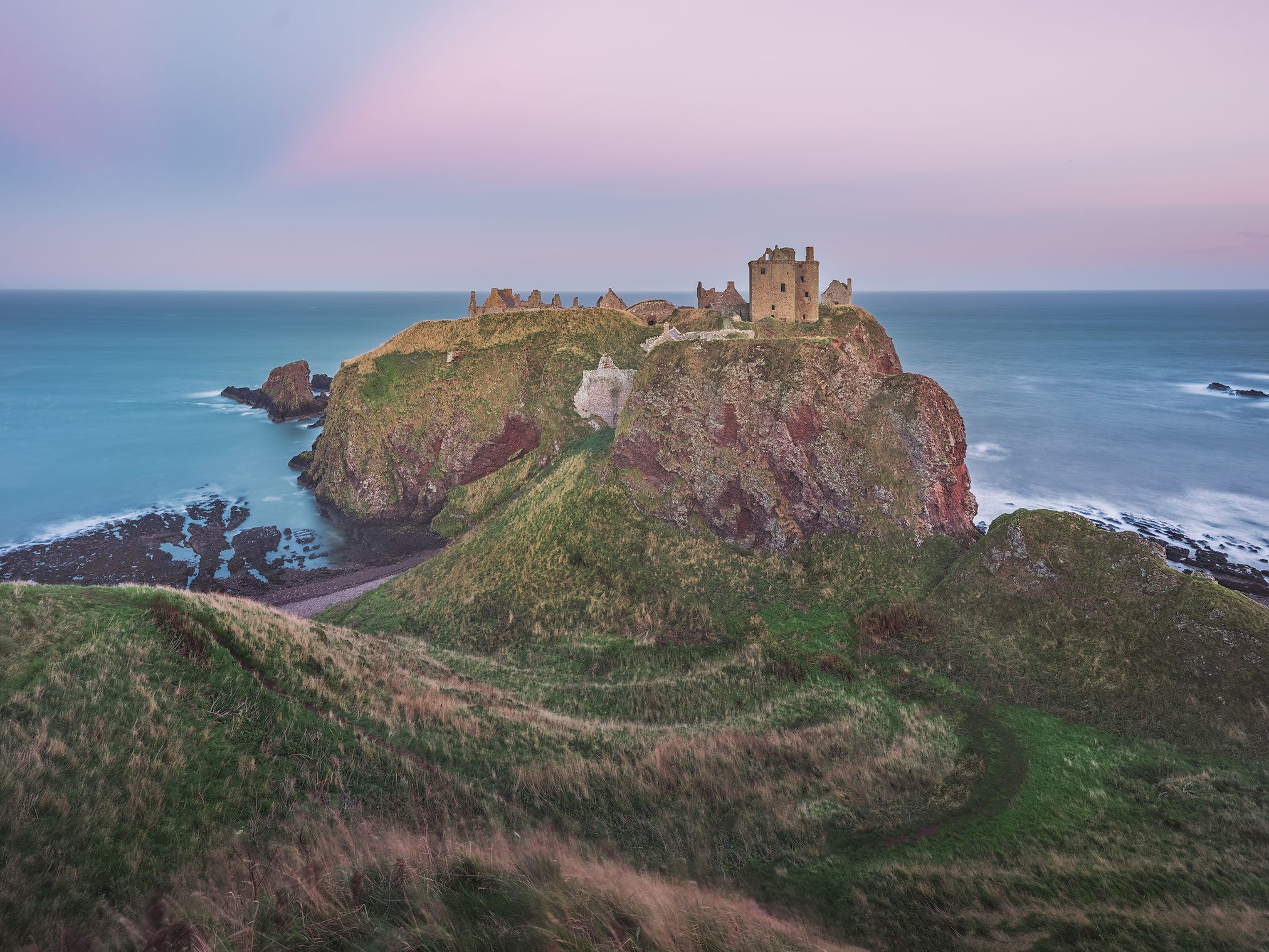 Castle ruin on a rocky headland above the sea in Scotland