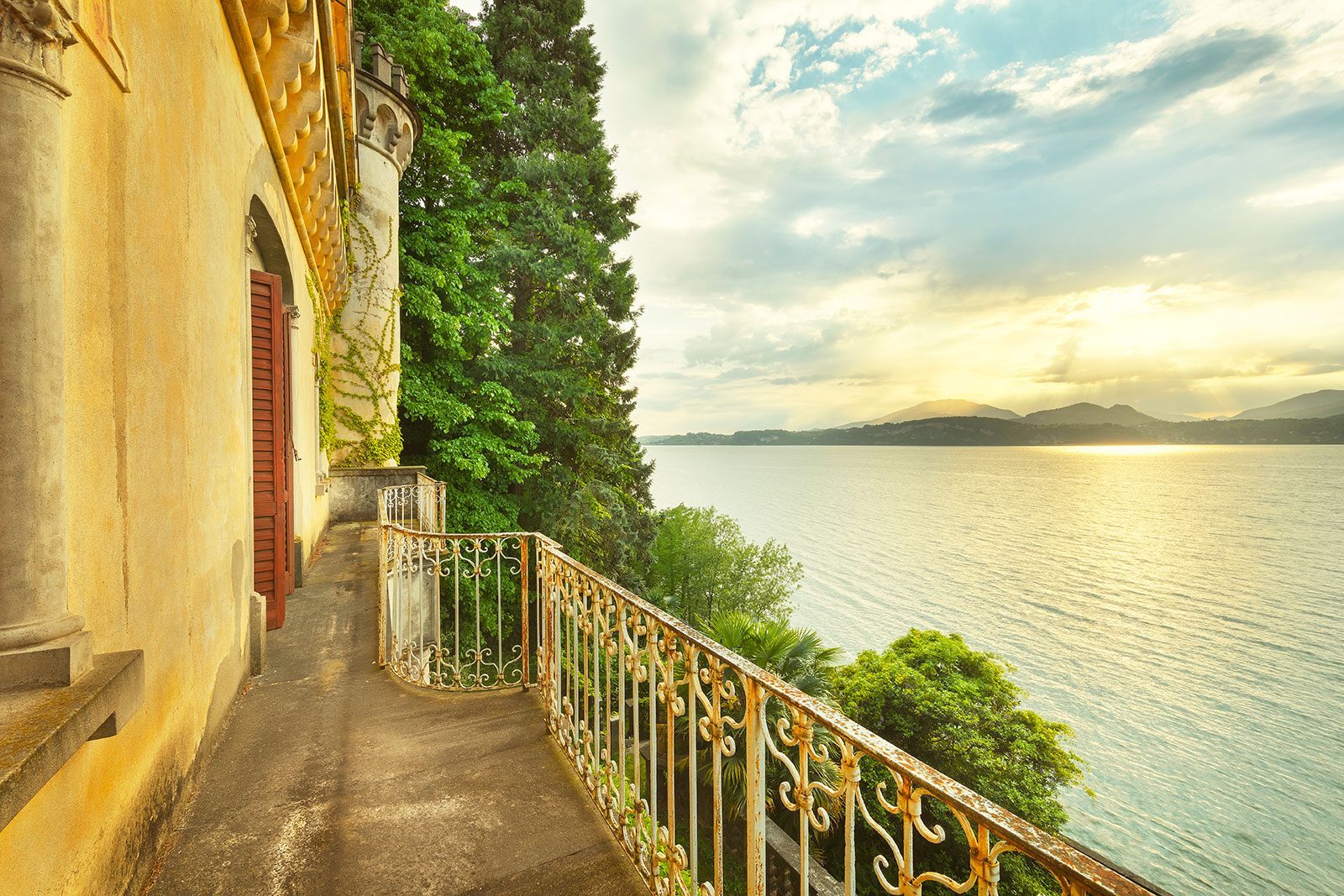 Balcony with a wrought iron railing on a villa overlooking a lake, Italy