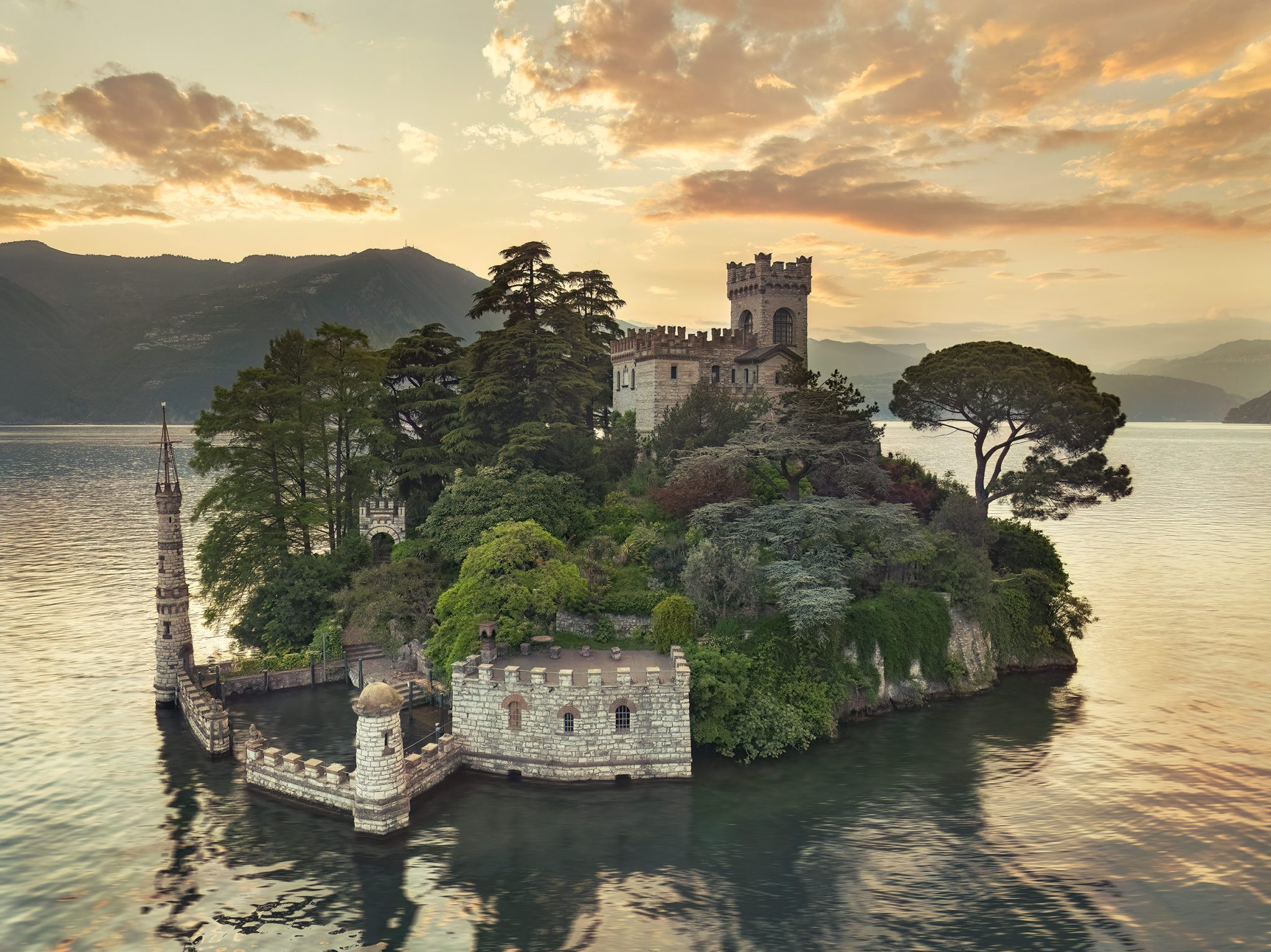 Castle island between wooded mountains on a lake in Italy