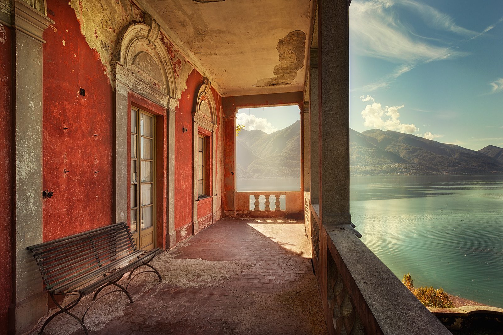Covered passage with red walls overlooking a lake, Italy