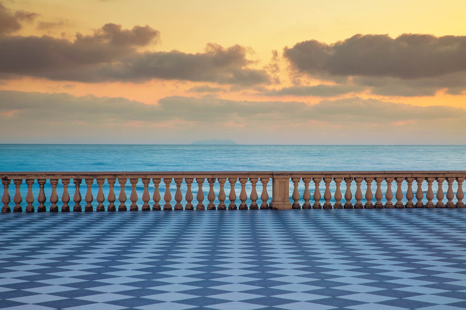 Empty square with a chequered tile pattern overlooking the sea, Italy