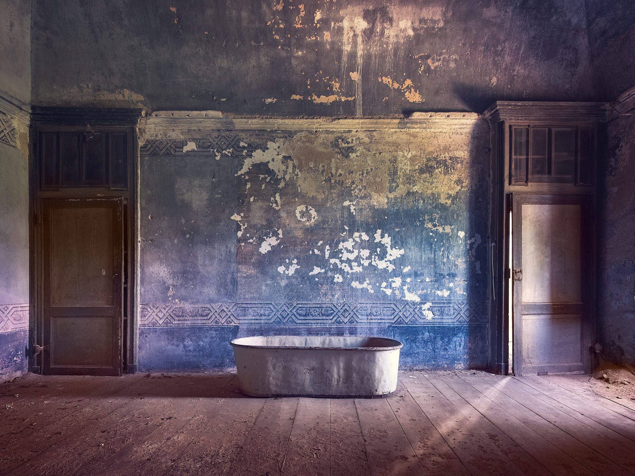 Alte Badewanne vor blauer Wand in einer verlassenen Villa in Italien