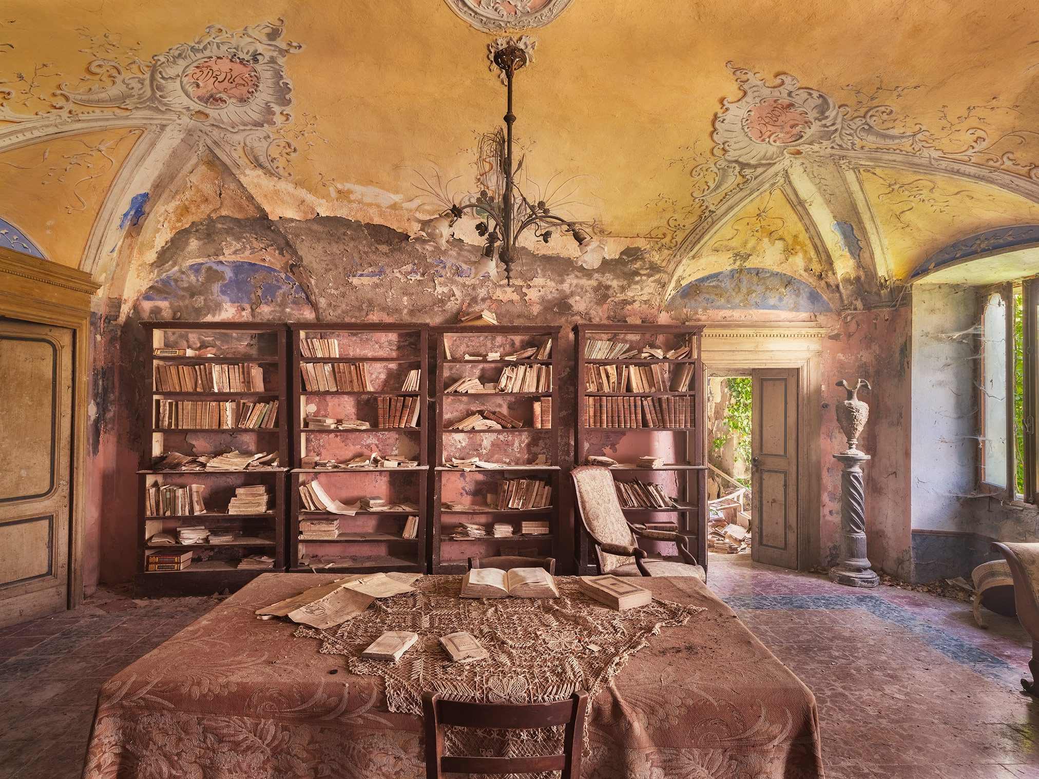 Library with a chandelier in an abandoned villa in Italy