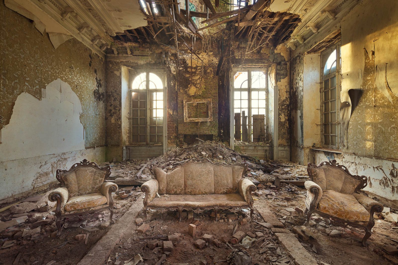 Eingestürzter Salon mit drei Sofas in einem heute abgerissenen Château in Belgien