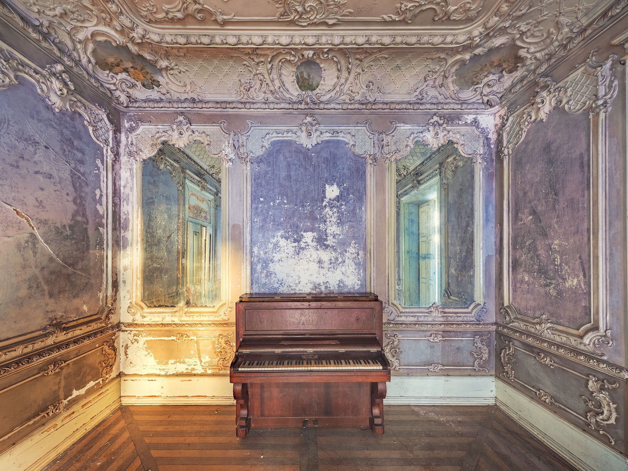 Piano in einem stuckverzierten Saal einer vergessenen Villa in Portugal