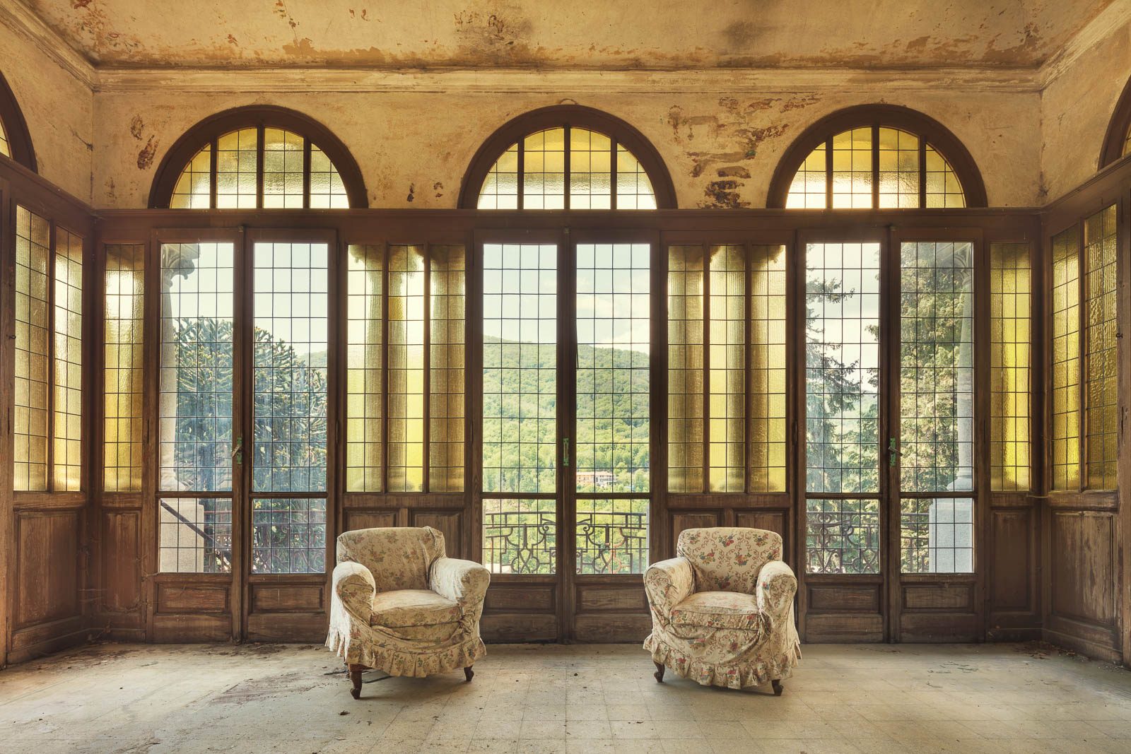 Zwei Sessel vor Panoramafenstern in einer verlassenen Jugendstil-Villa in Italien