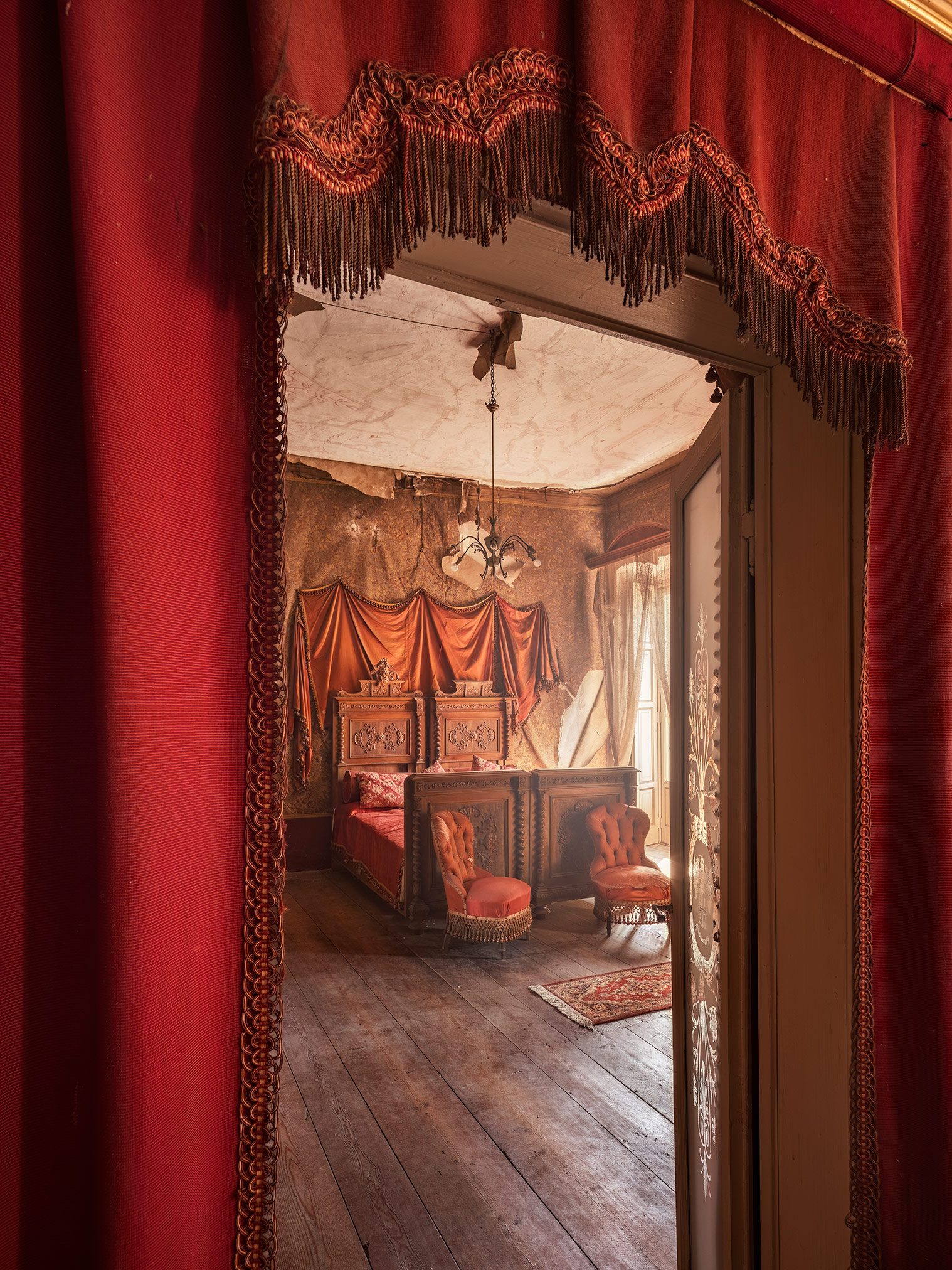 View through a red curtain into a bedroom at Villa Siotto Pittor near Bergamo, Italy