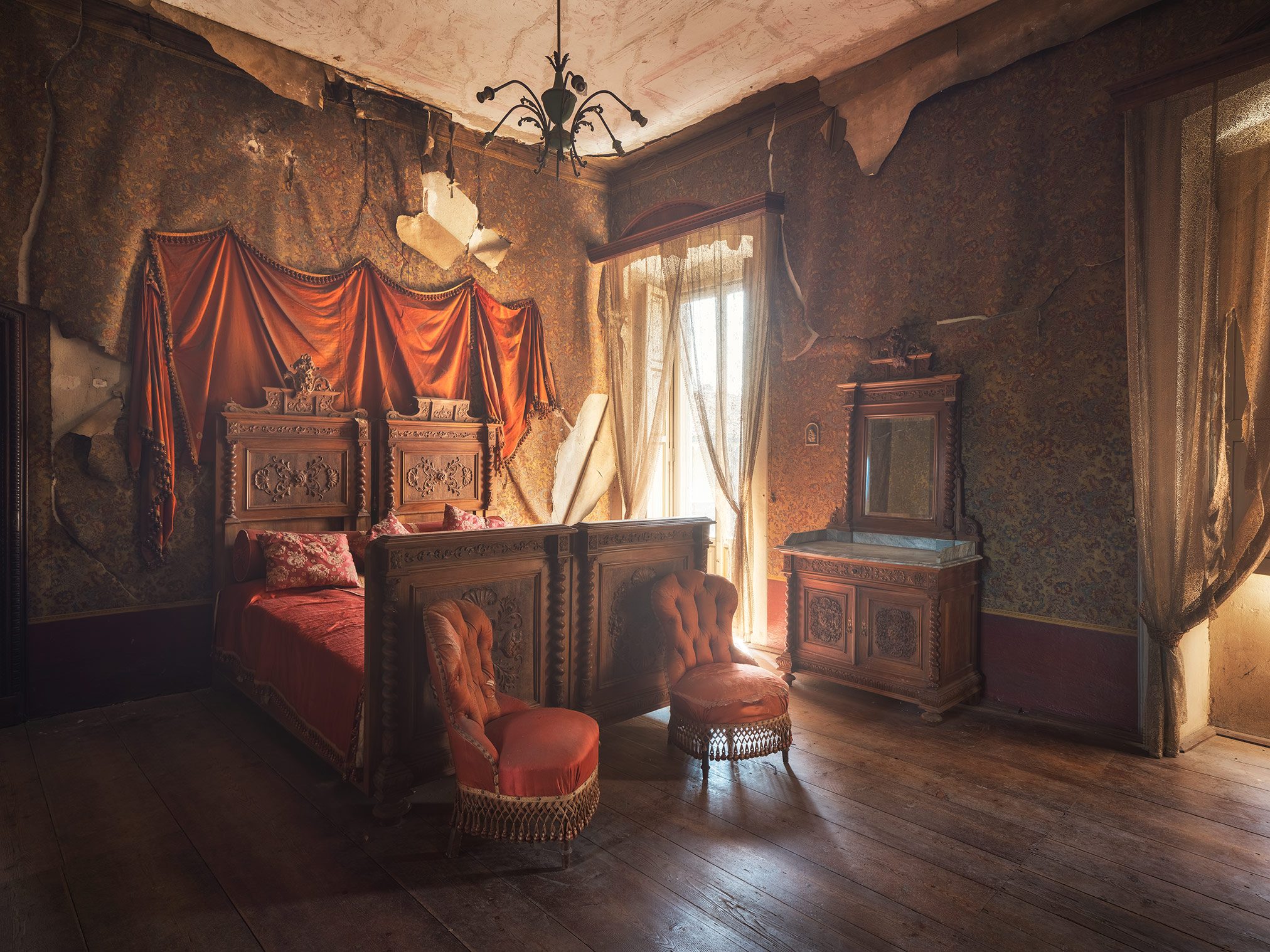 Bedroom with a red bed canopy in the historic Villa Siotto Pittor near Bergamo, Italy