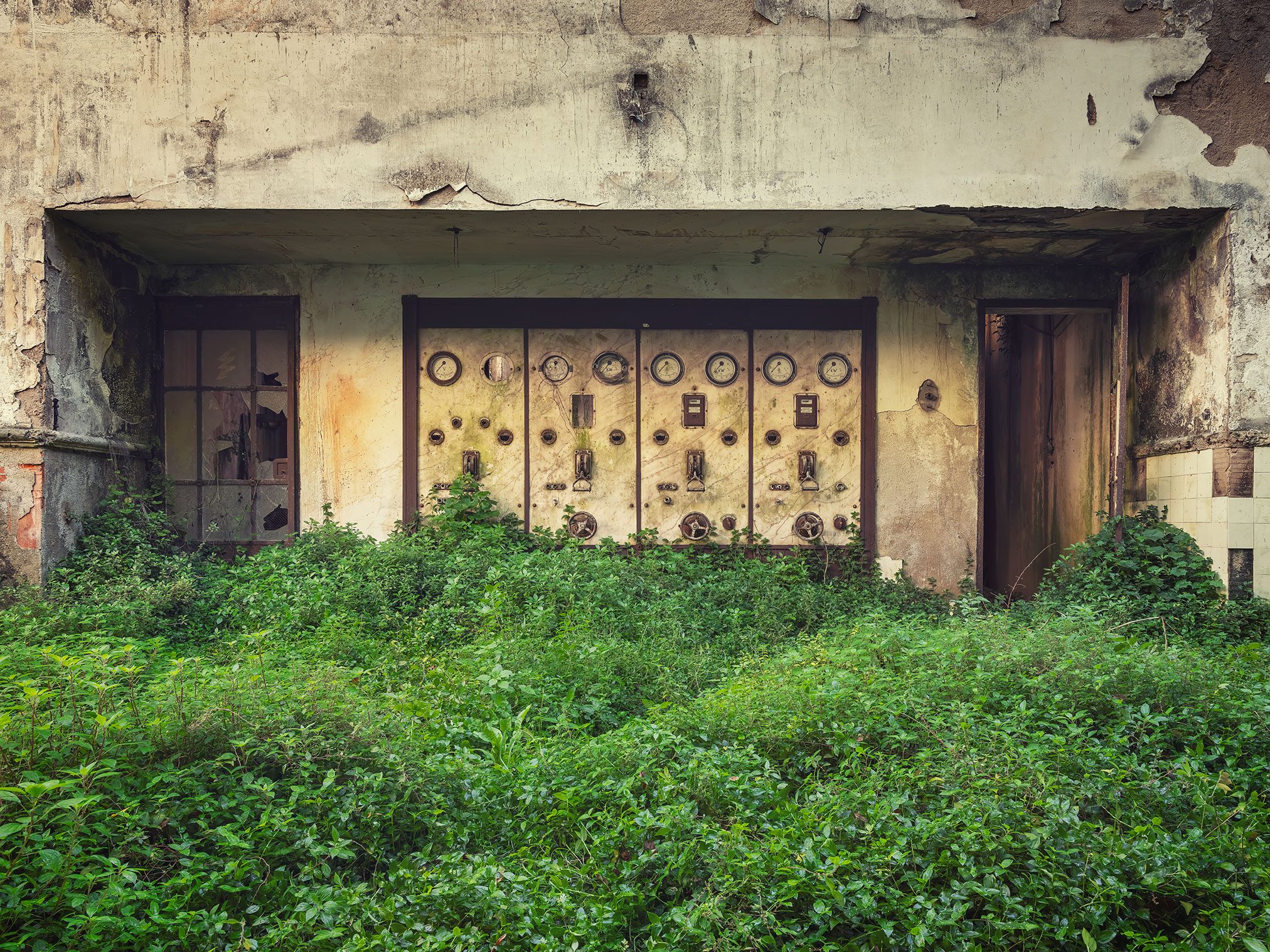 Overgrown control panel with gauges in a hydroelectric plant in Portugal