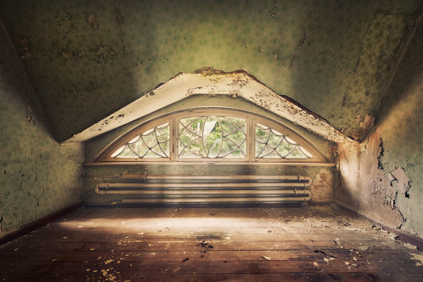 Attic room with an arched lattice window and a radiator in a former hunting lodge in Thuringia, Germany