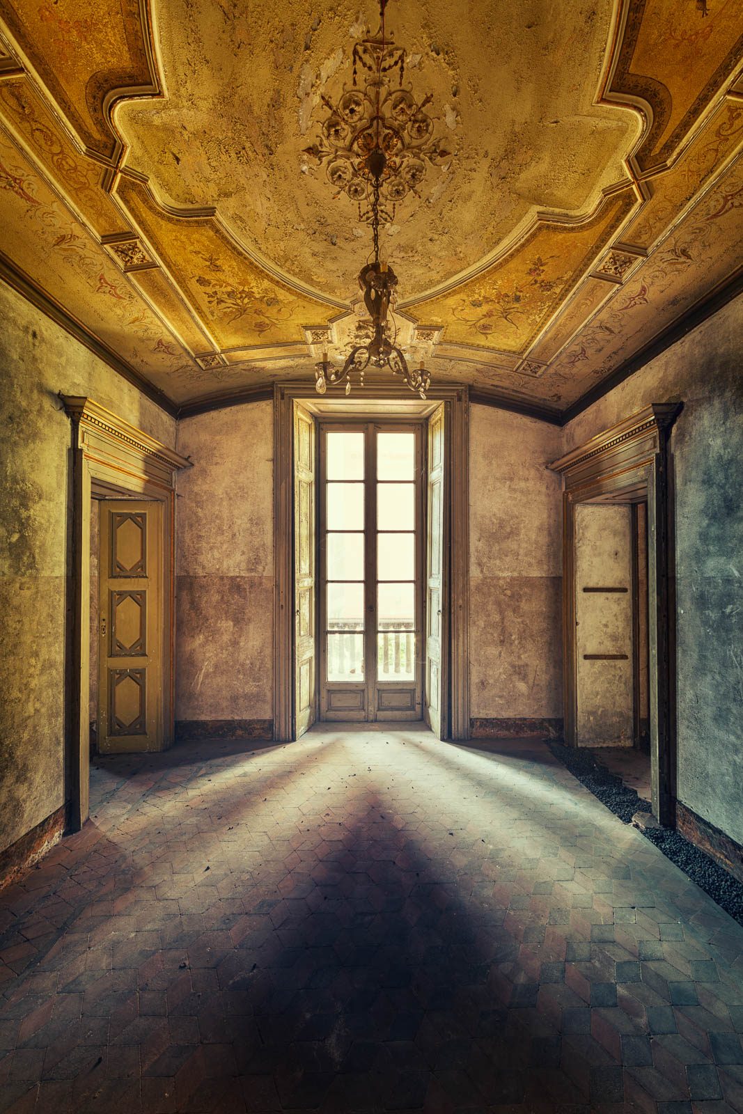 Hall with a gilded coffered ceiling and two chandeliers in a historic palace in the province of Novara, Piedmont, Italy