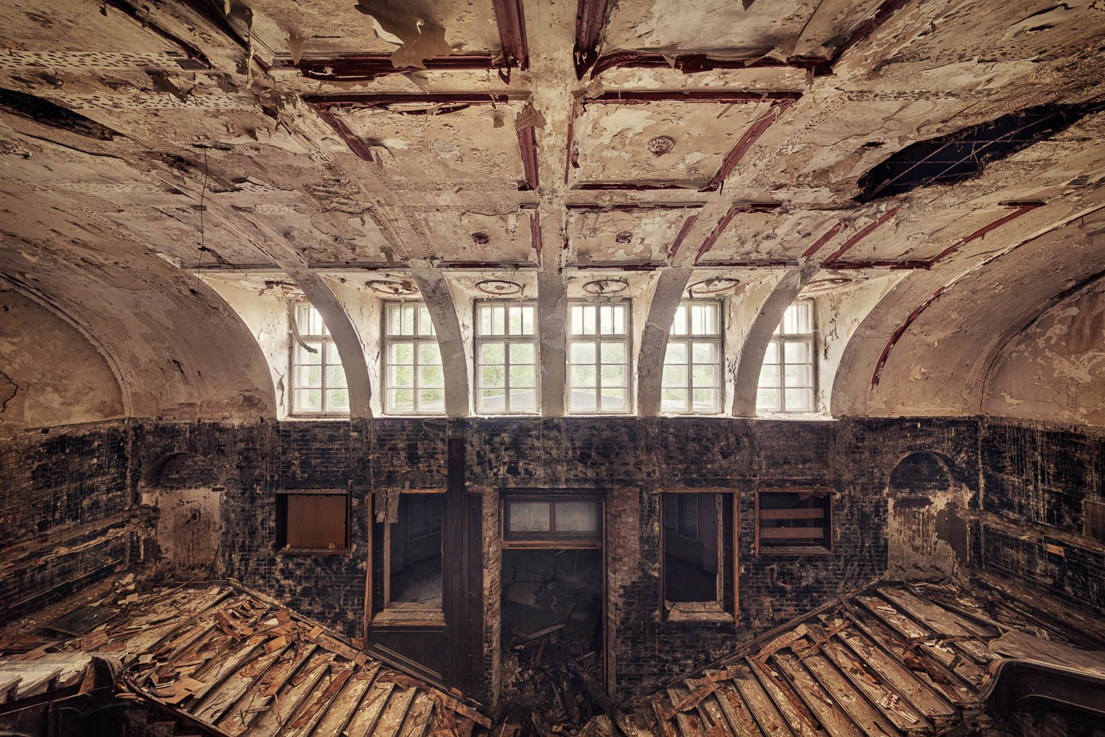 View from a gallery onto collapsed roof beams in an old manor house and former school in Poland
