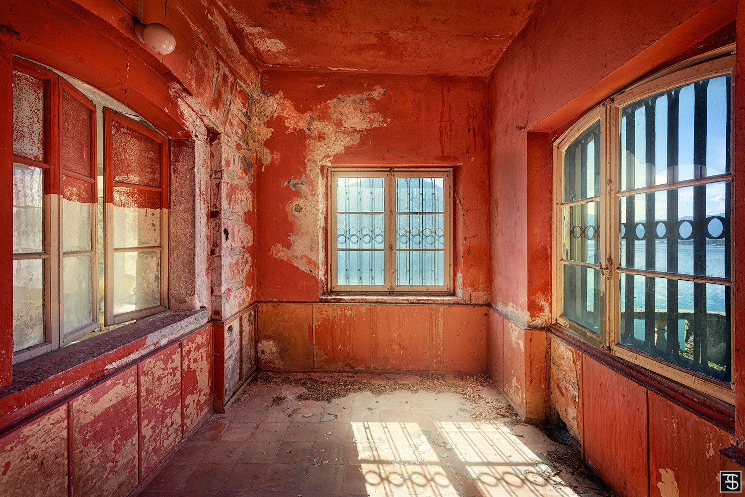 Rotes Zimmer mit vergitterten Fenstern und Seeblick in einer verlassenen Villa am Lago Maggiore