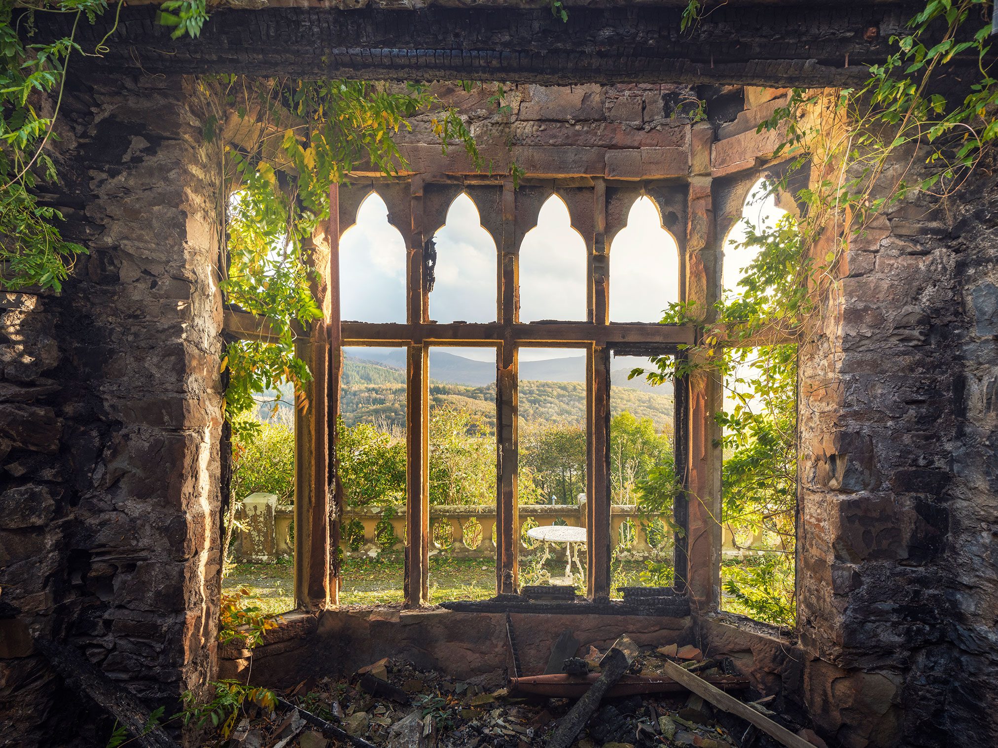 Blick durch ein gotisches Fenster in der Ruine eines noblen Hotels in Wales