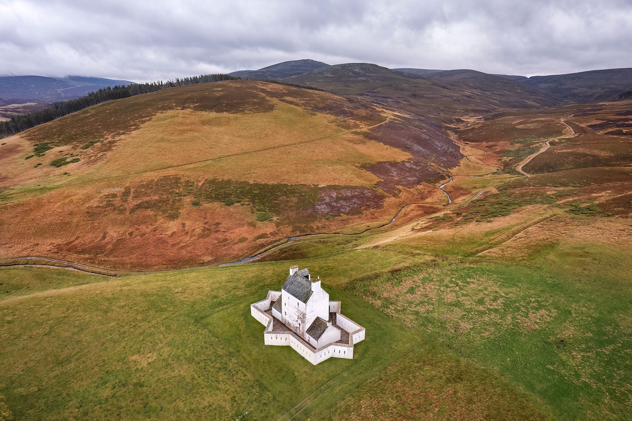 Weiß getünchtes Turmhaus mit sternförmiger Wehrmauer im Moorland, Schottland