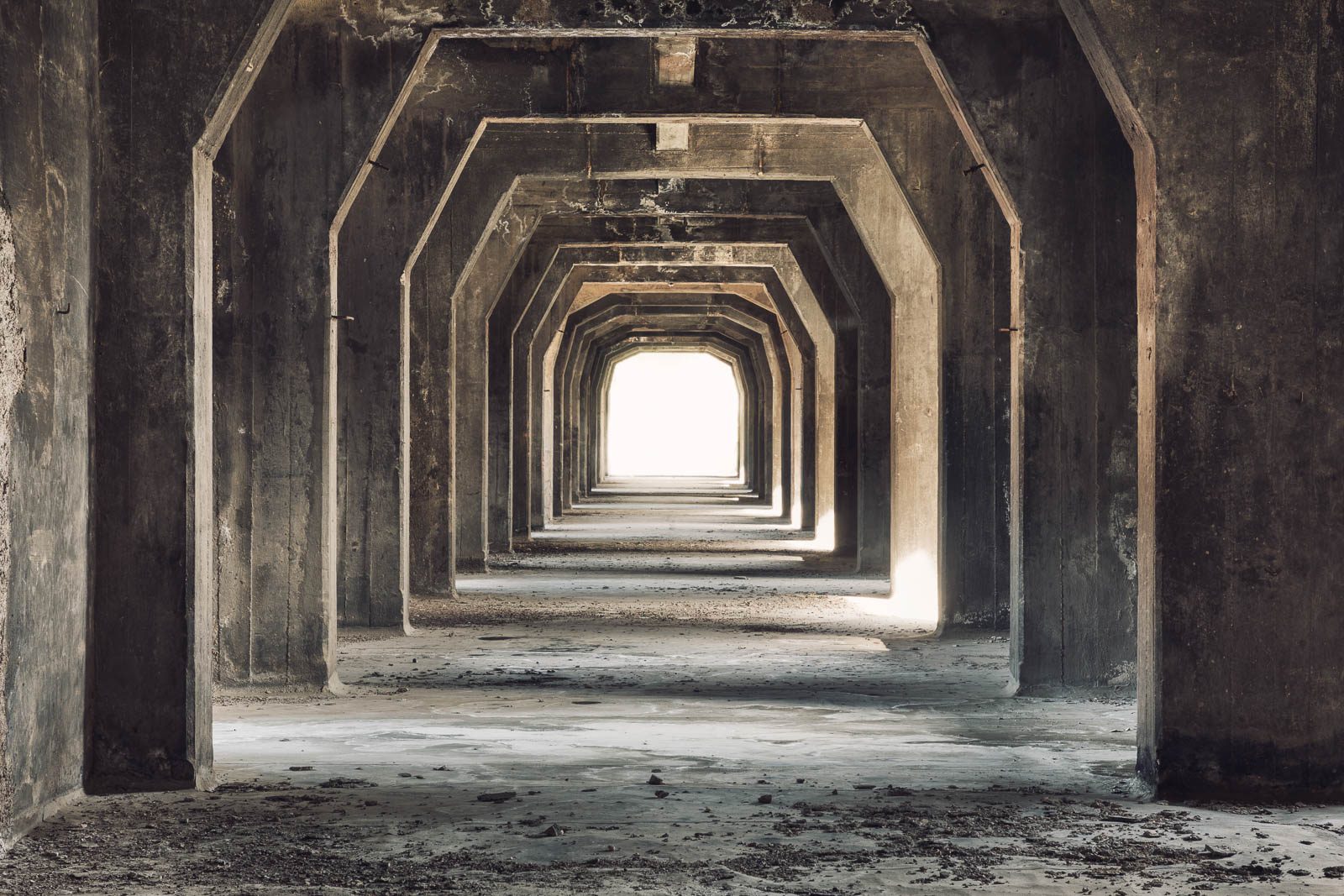 Octagonal corridor with a bright point of light at the end in an industrial facility in Italy