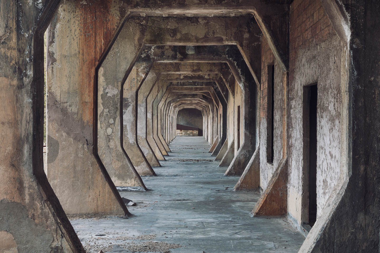 Octagonal corridor with repeating concrete frames in an industrial facility in Italy