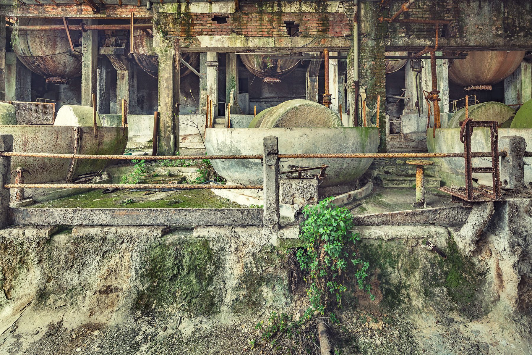 Round tanks on the facade of an abandoned paper factory in Italy
